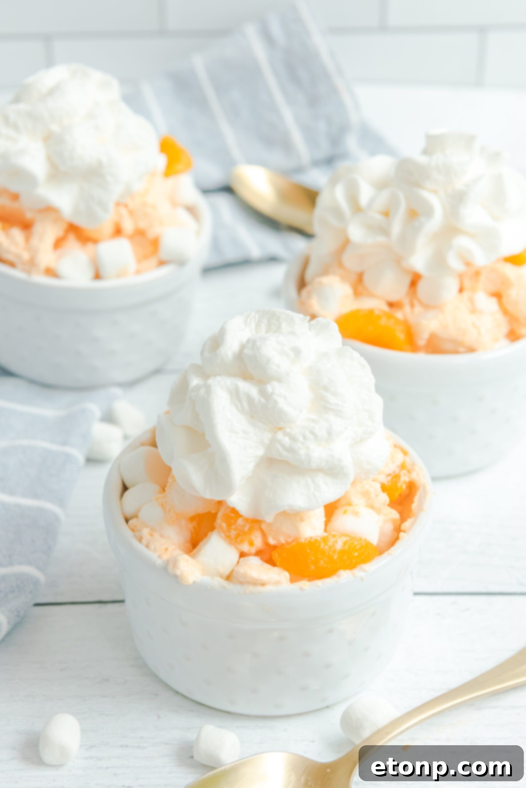 A beautifully presented bowl of Orange Creamsicle Salad, generously topped with whipped cream, ready for serving.