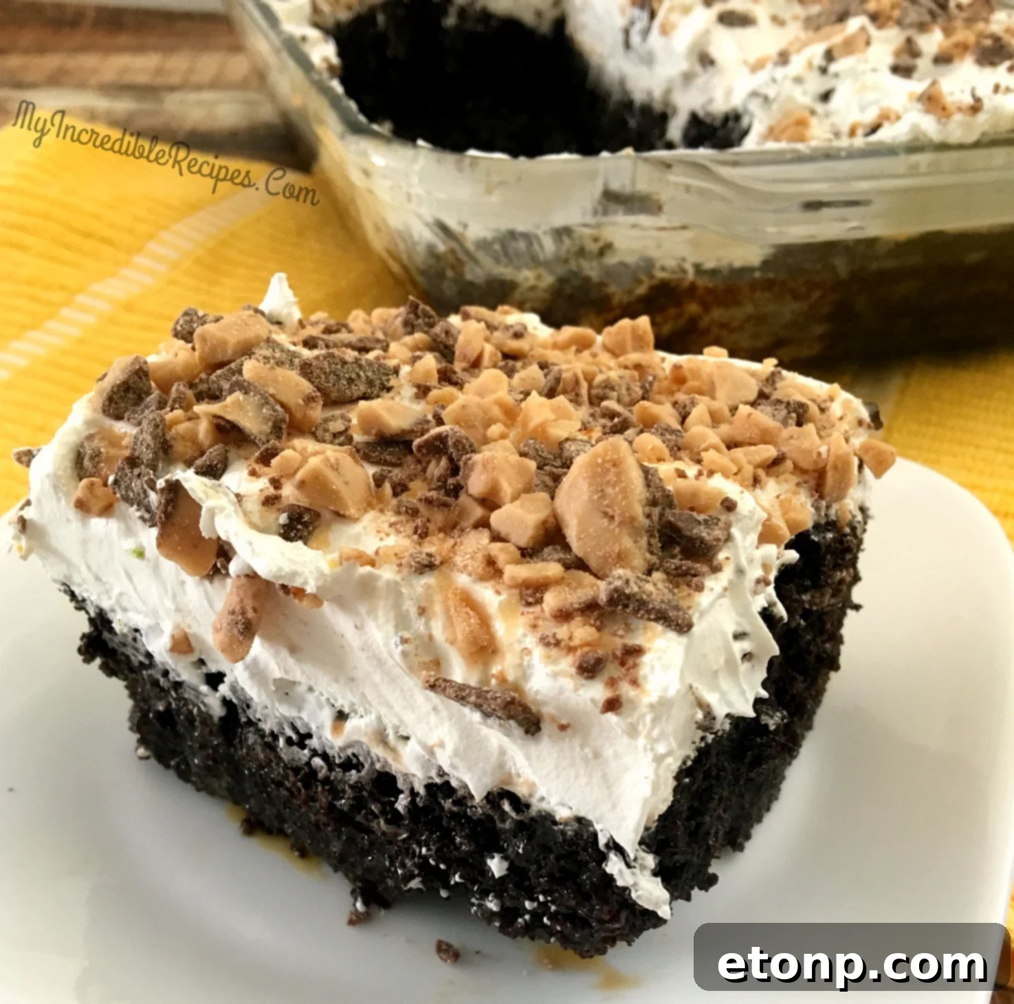 Decadent chocolate poke cake drizzled with rich caramel, topped with a generous layer of whipped cream and crunchy Heath bar pieces.