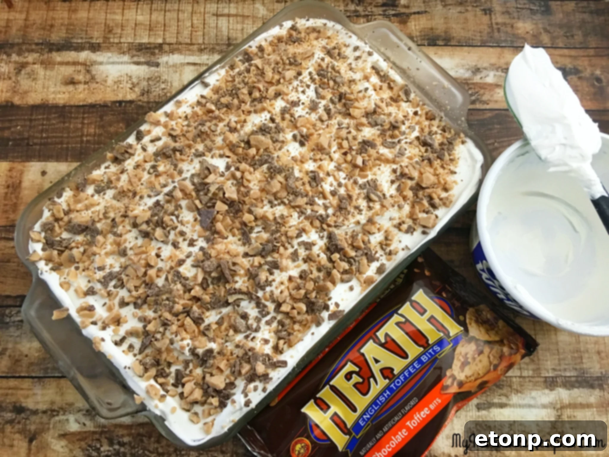 Detailed shot of the cake's delicious topping, featuring the textural contrast of the crisp Heath bar bits against the smooth, creamy whipped topping.