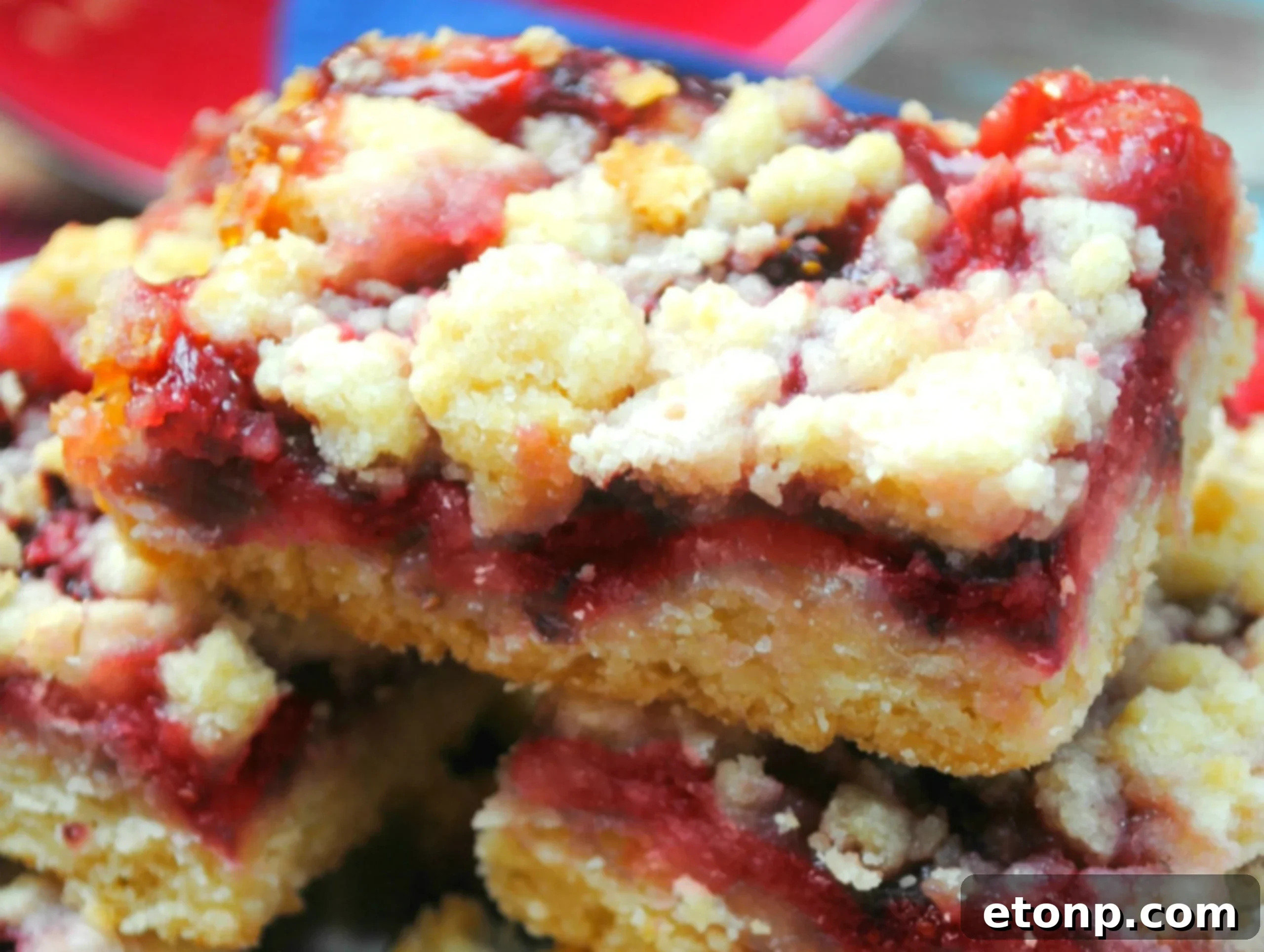 Close-up of freshly baked Raspberry Crumble Bars, showcasing golden crust and vibrant red raspberry filling.