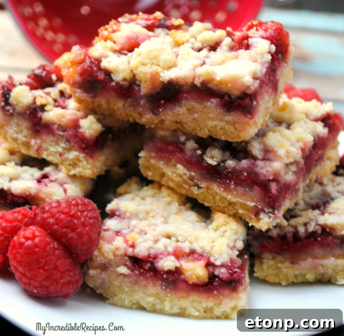 Close-up of a single Raspberry Crumble Bar, showing the thick raspberry layer and crumbly topping.