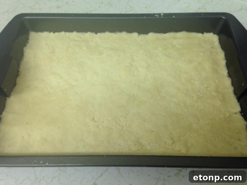 Side view of a Raspberry Crumble Bar, highlighting the distinct layers of crust, fruit, and crumble.