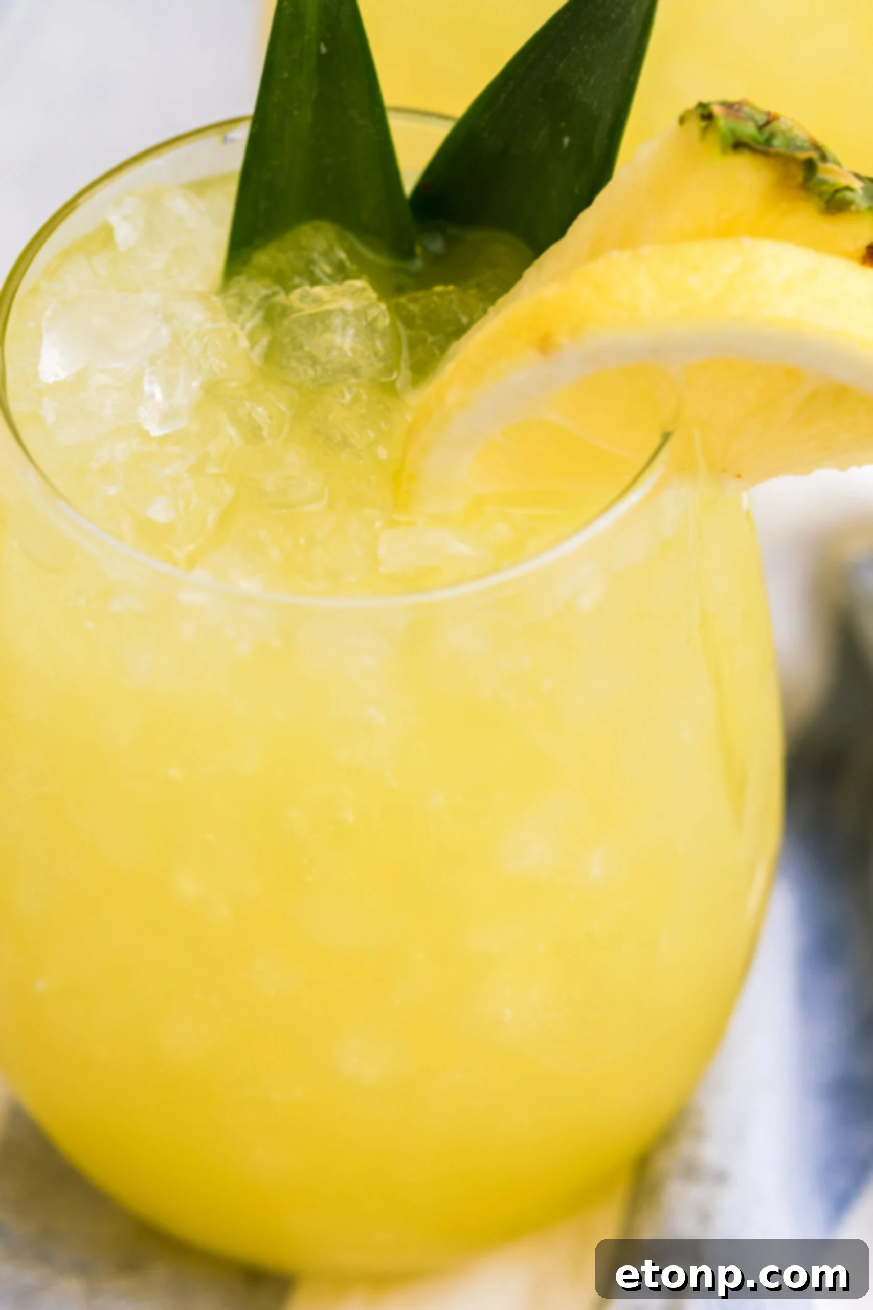 Close-up shot of Pineapple Lemonade in a clear glass with ice, showcasing its refreshing texture