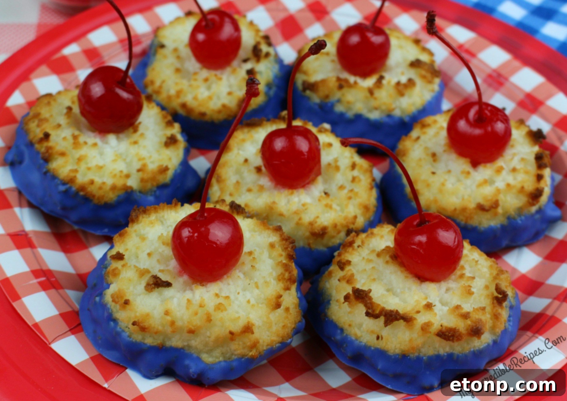 Finished coconut macaroons cooling on a wire rack, with some dipped in chocolate and topped with cherries