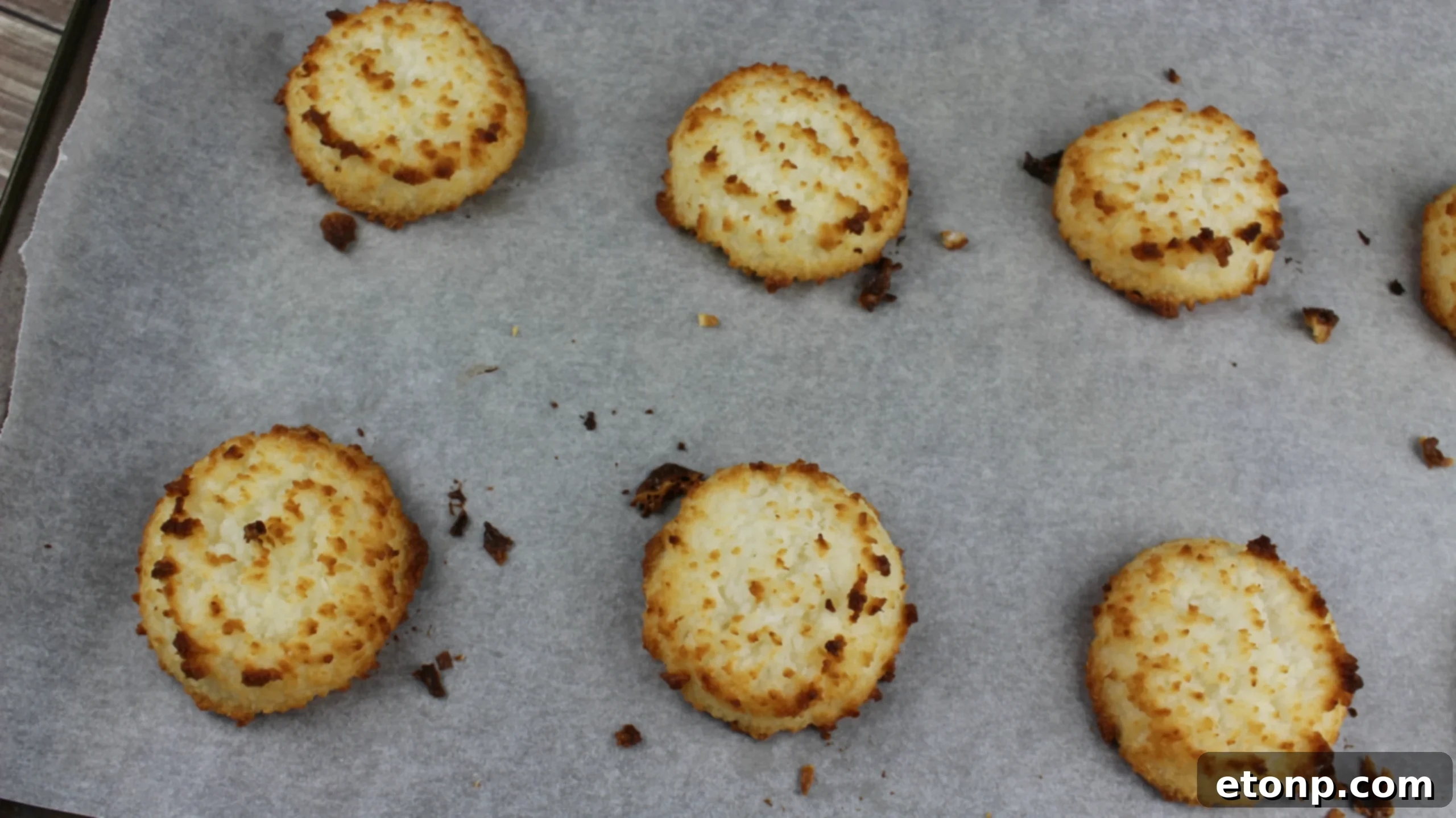 Coconut macaroon mixture being scooped onto a parchment-lined baking sheet