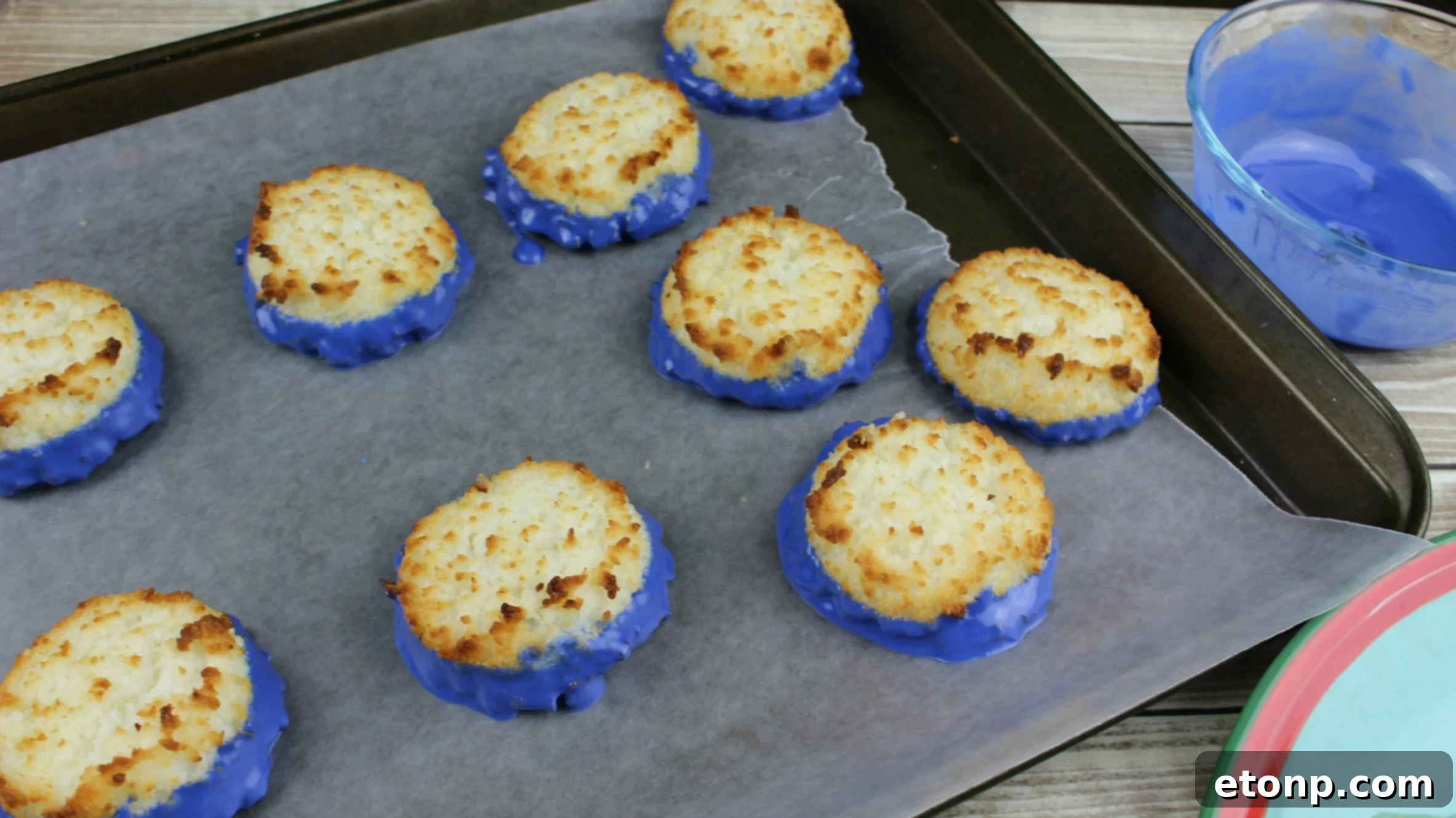 A finished coconut macaroon cherry bomb with blue chocolate and a bright red cherry on top