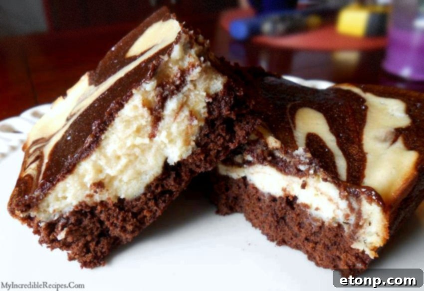 Rich, fudgy cream cheese swirl brownies with a marbled pattern, presented beautifully on a plate.