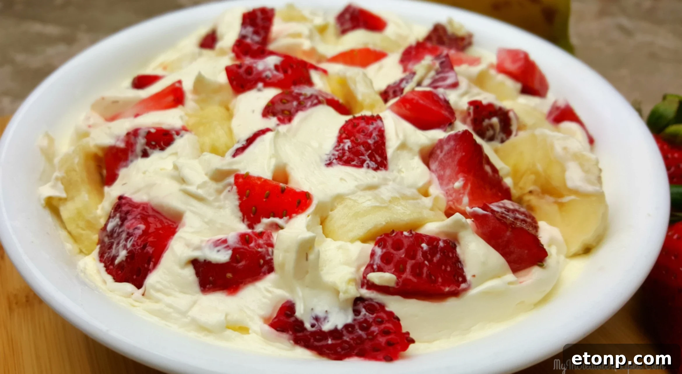 Strawberry Banana Cheesecake Salad Bliss 2 A vibrant bowl of Strawberry Banana Cheesecake Salad, garnished with fresh fruit, inviting a delightful dessert experience.