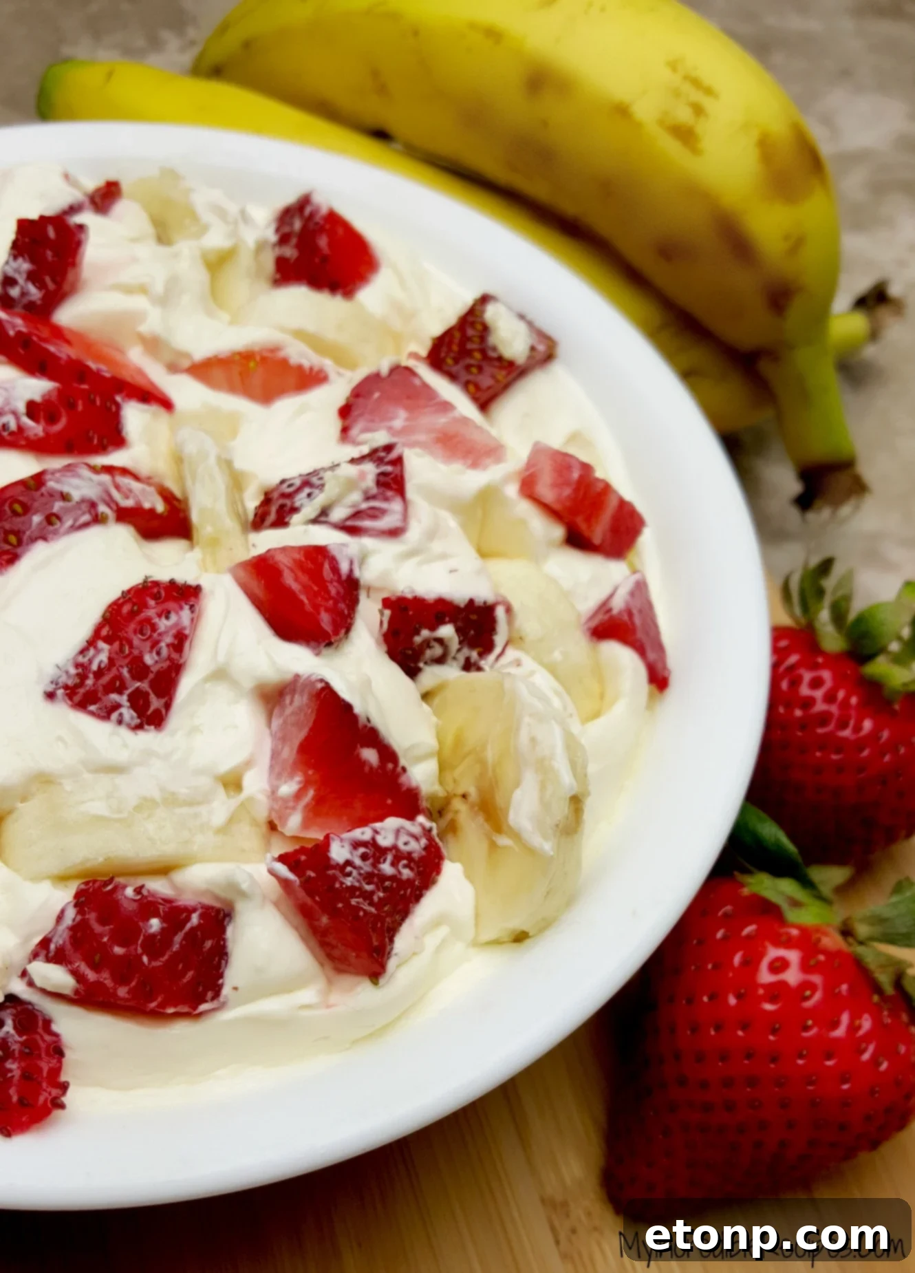 Strawberry Banana Cheesecake Salad Bliss 12 A generous serving of Strawberry Banana Cheesecake Salad in a glass bowl, showcasing its layers.