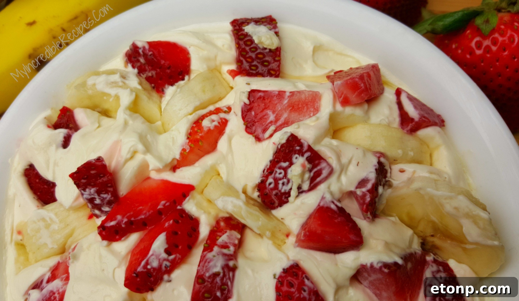 Strawberry Banana Cheesecake Salad Bliss 4 A large serving bowl filled with Strawberry Banana Cheesecake Salad, ready to be enjoyed at a gathering or party.