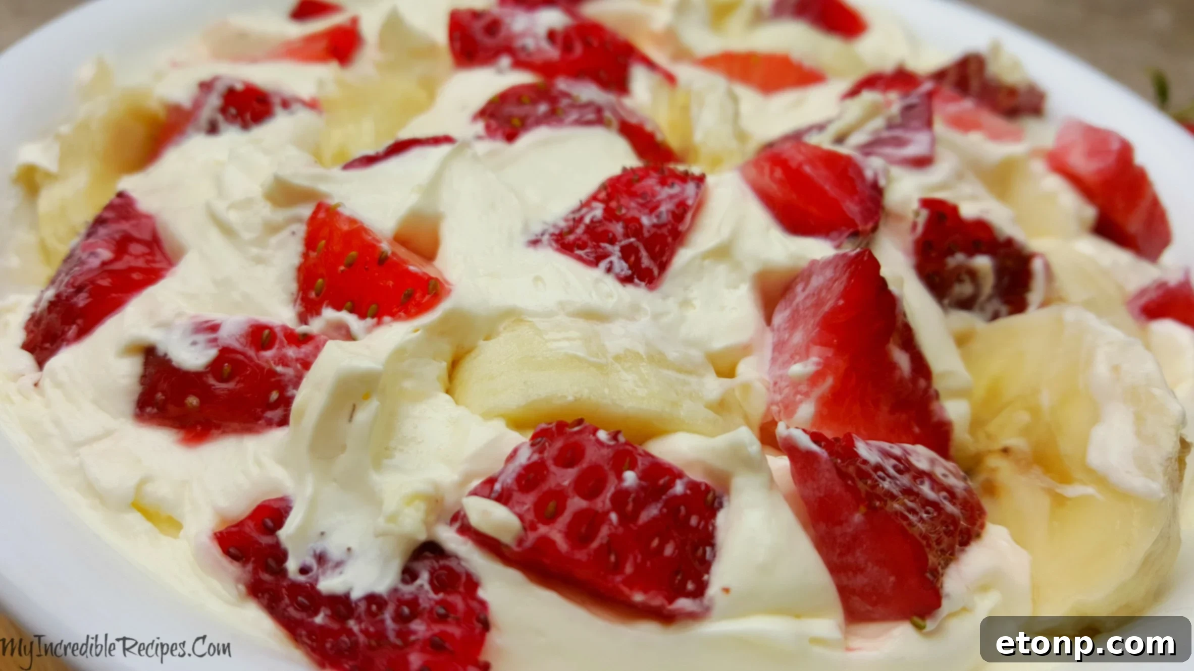 Strawberry Banana Cheesecake Salad Bliss 5 A scoop of Strawberry Banana Cheesecake Salad being served onto a plate, highlighting its creamy texture and fruit chunks.