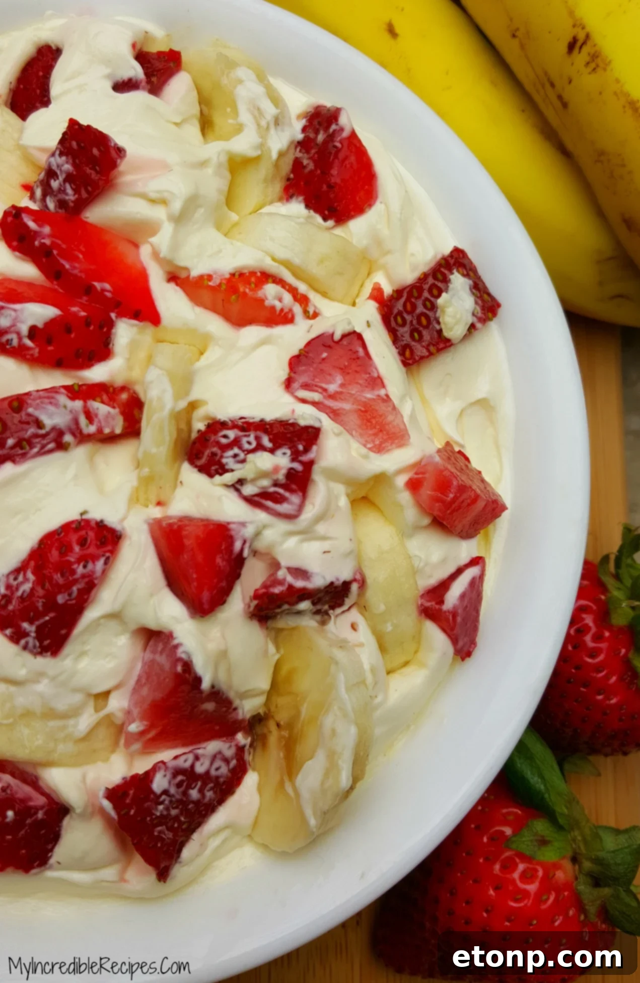 Strawberry Banana Cheesecake Salad Bliss 8 A large bowl of Strawberry Banana Cheesecake Salad covered and stored in a refrigerator, indicating freshness.
