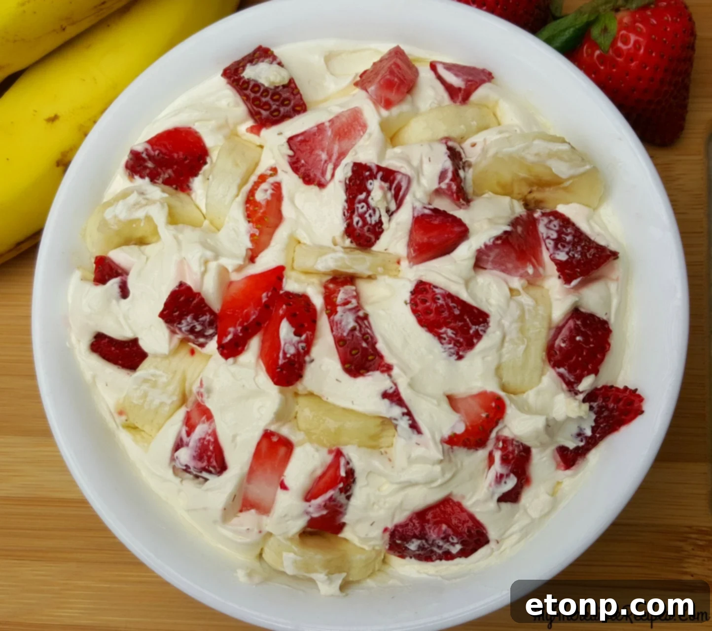 Strawberry Banana Cheesecake Salad Bliss 9 A bowl of Strawberry Banana Cheesecake Salad with additional fruit garnishes, showcasing its inviting appearance.