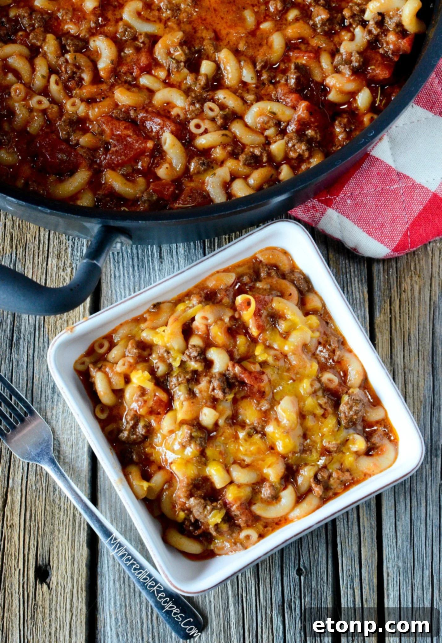 Homestyle Goulash 8 Old Fashioned Goulash in a pot with a white bowl filled with some topped with cheese