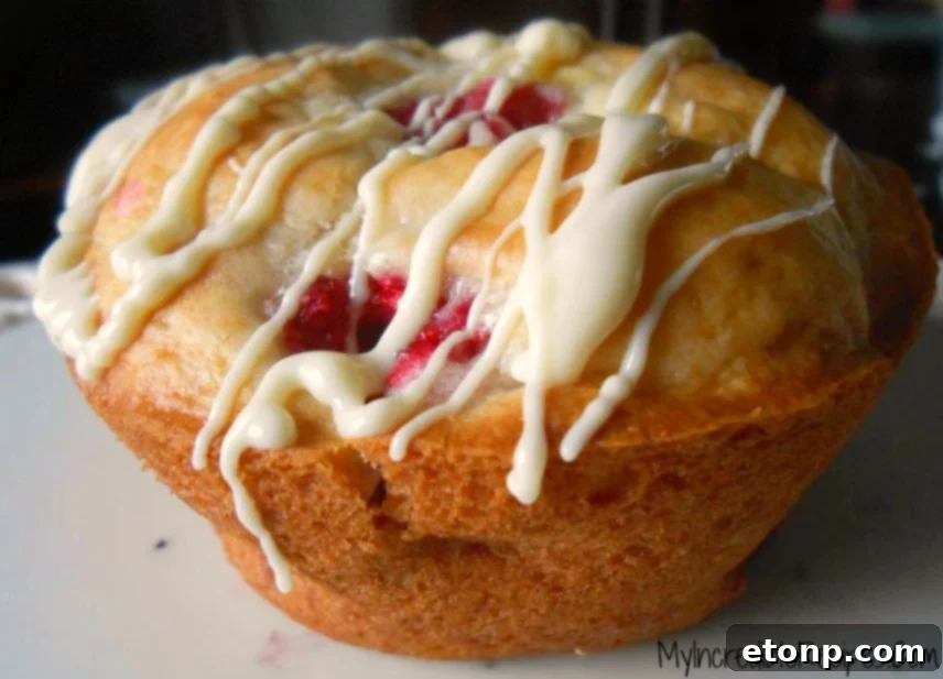 White Chocolate Raspberry Muffins with a Secret Ingredient 2 Delicious White Chocolate Raspberry Muffins fresh from the oven, showcasing their golden-brown tops and juicy raspberries.