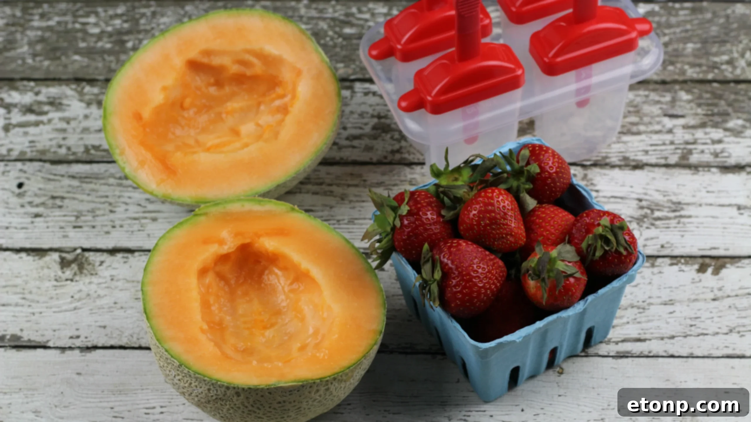 Fresh ingredients for homemade Strawberry Cantaloupe Popsicles, including whole fruits