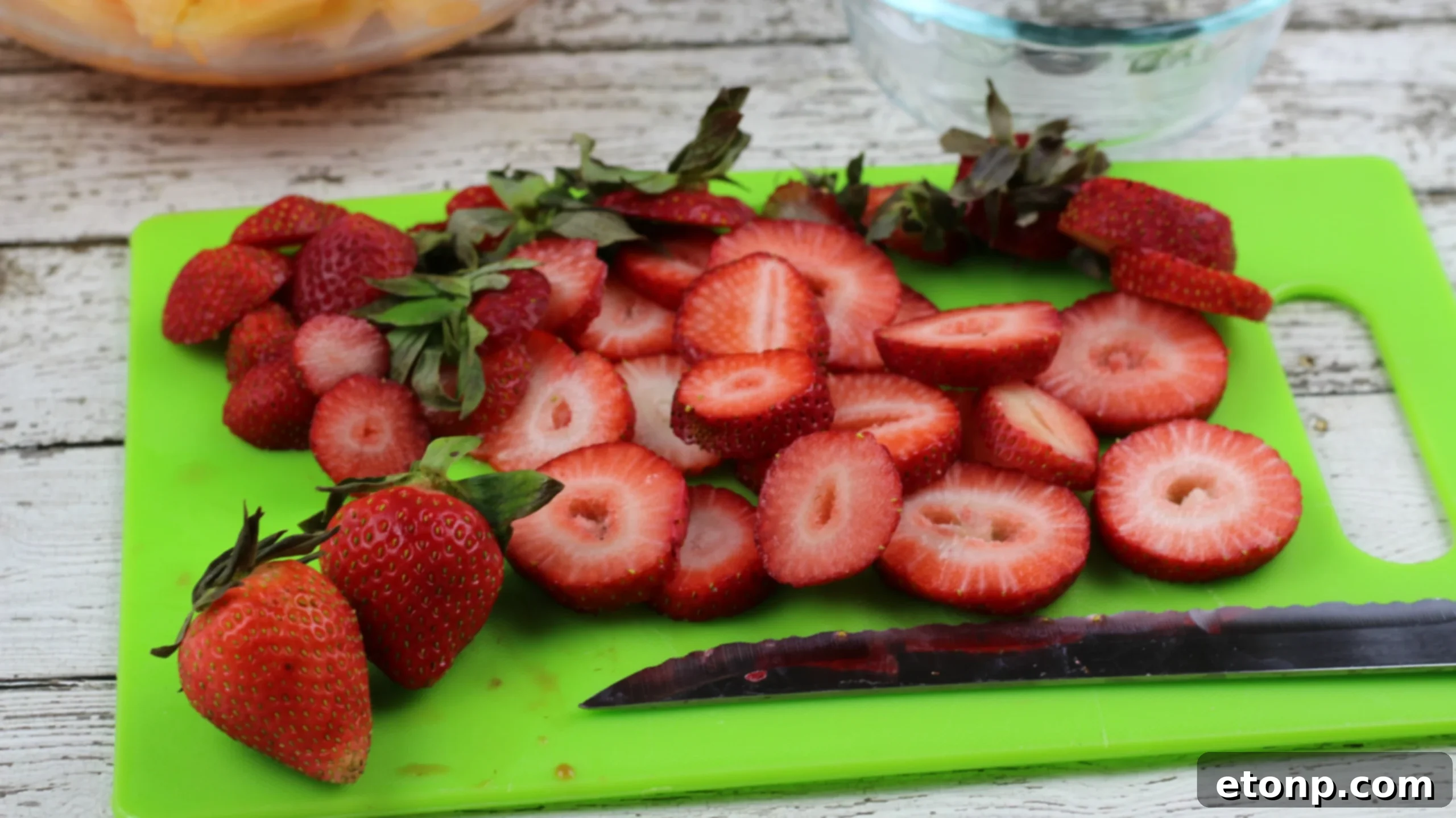 Diced cantaloupe and freshly sliced strawberries arranged for blending