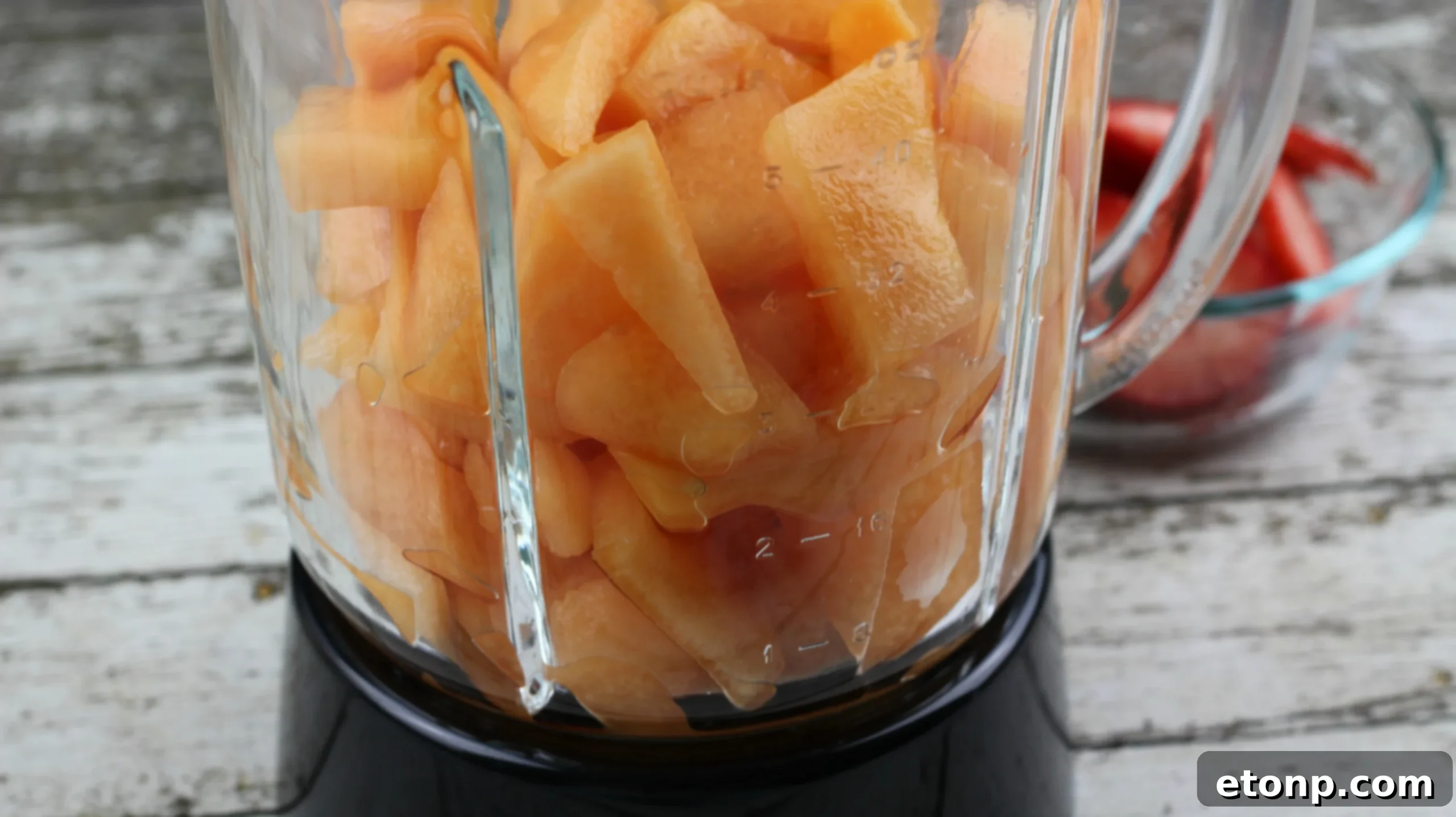 Pouring the blended fruit mixture into popsicle molds for freezing