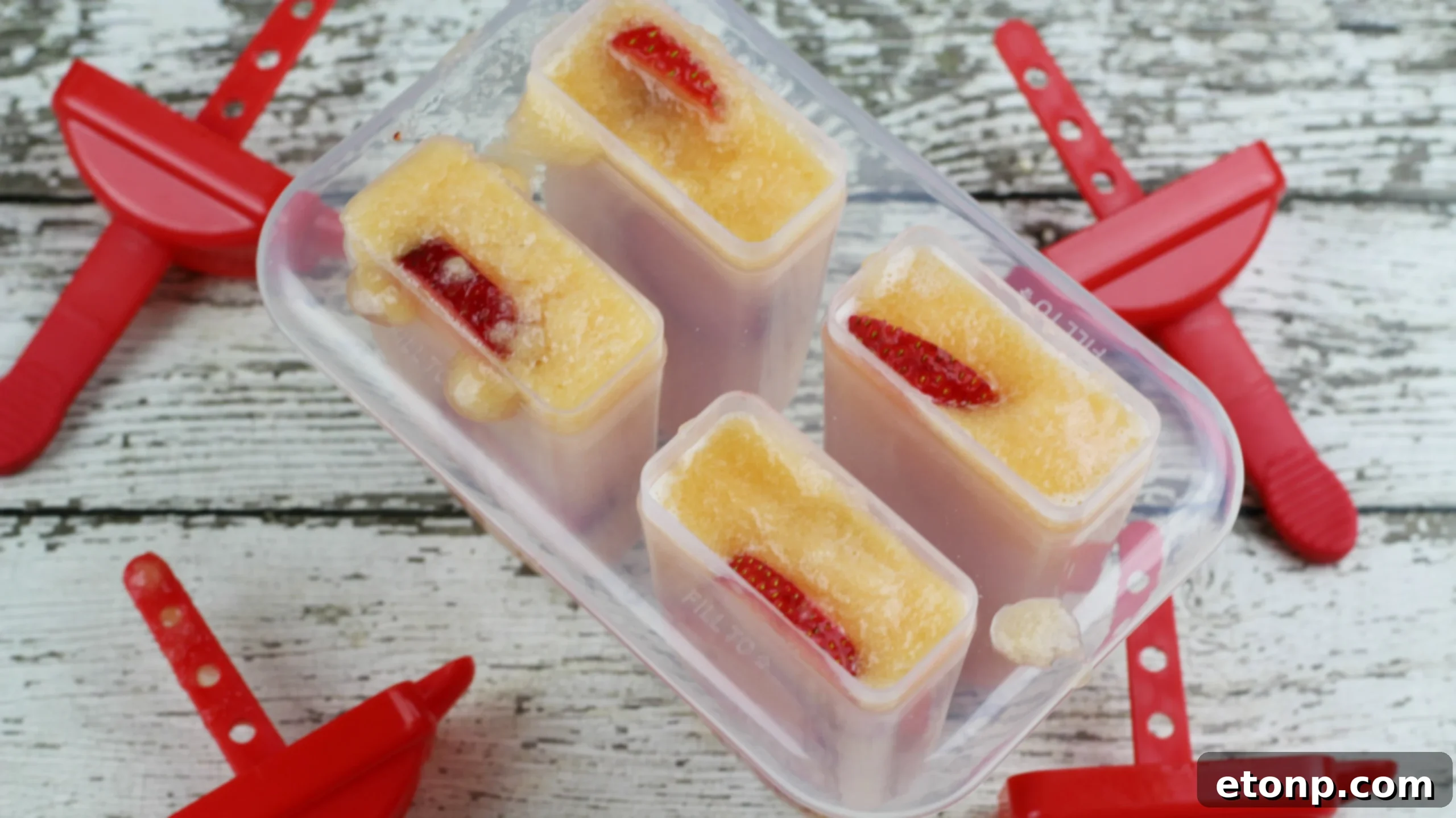 Close-up of a Strawberry Cantaloupe Sangria Popsicle garnished with fresh mint leaves