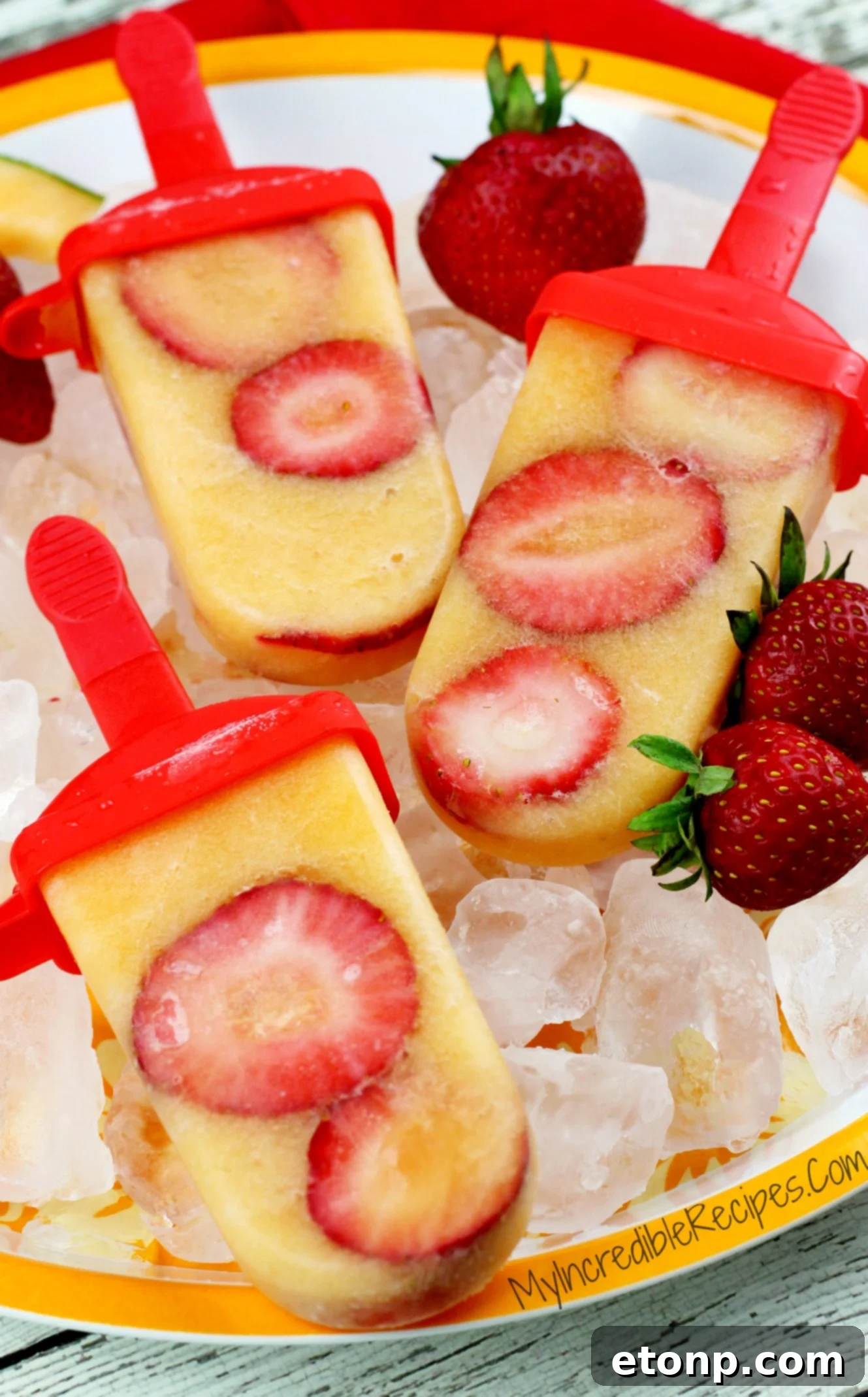 A close-up of a refreshing Strawberry Cantaloupe popsicle with visible fruit chunks