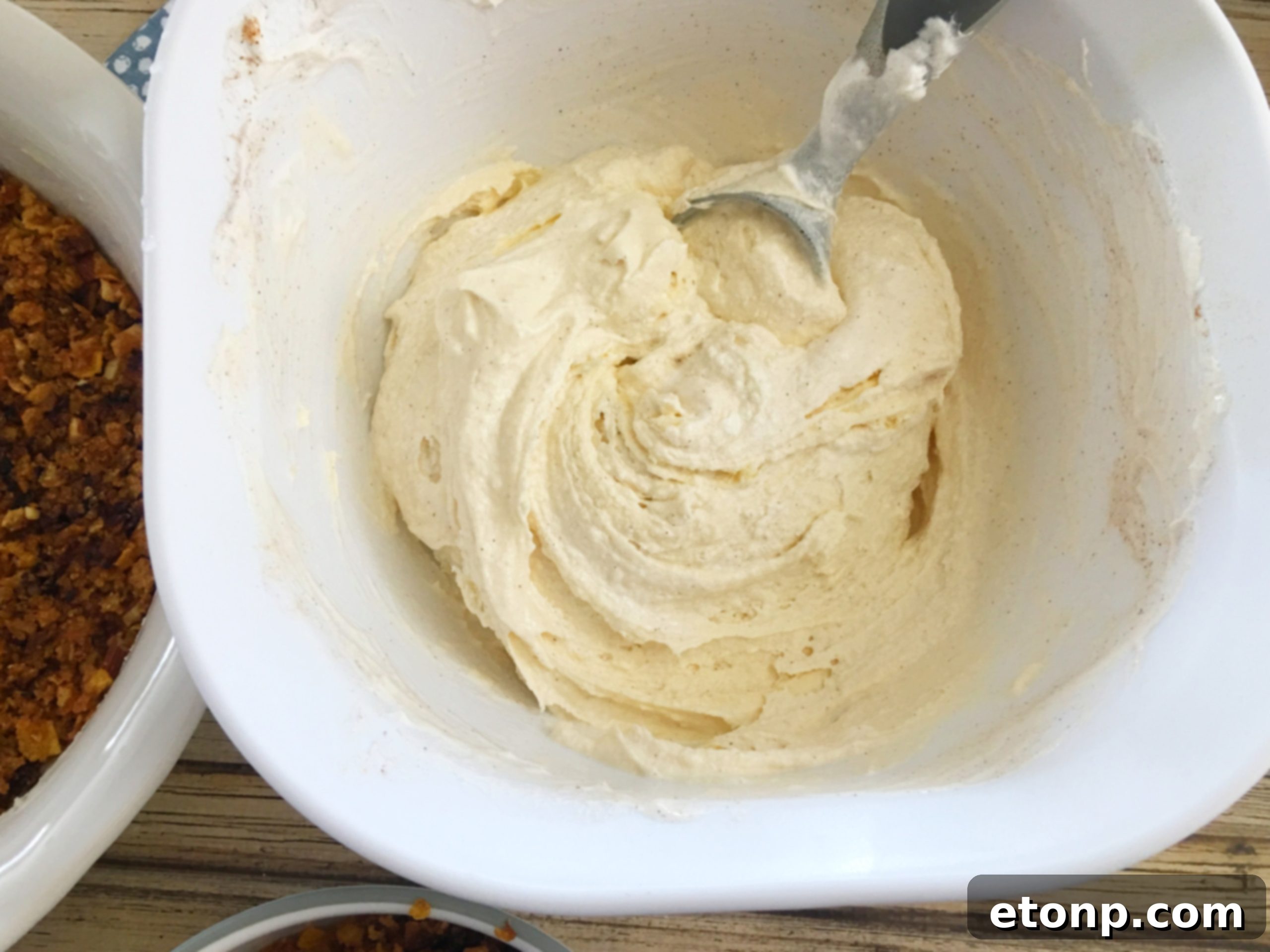 Mixing the softened ice cream, whipped topping, condensed milk, and cinnamon in a large bowl for the filling.