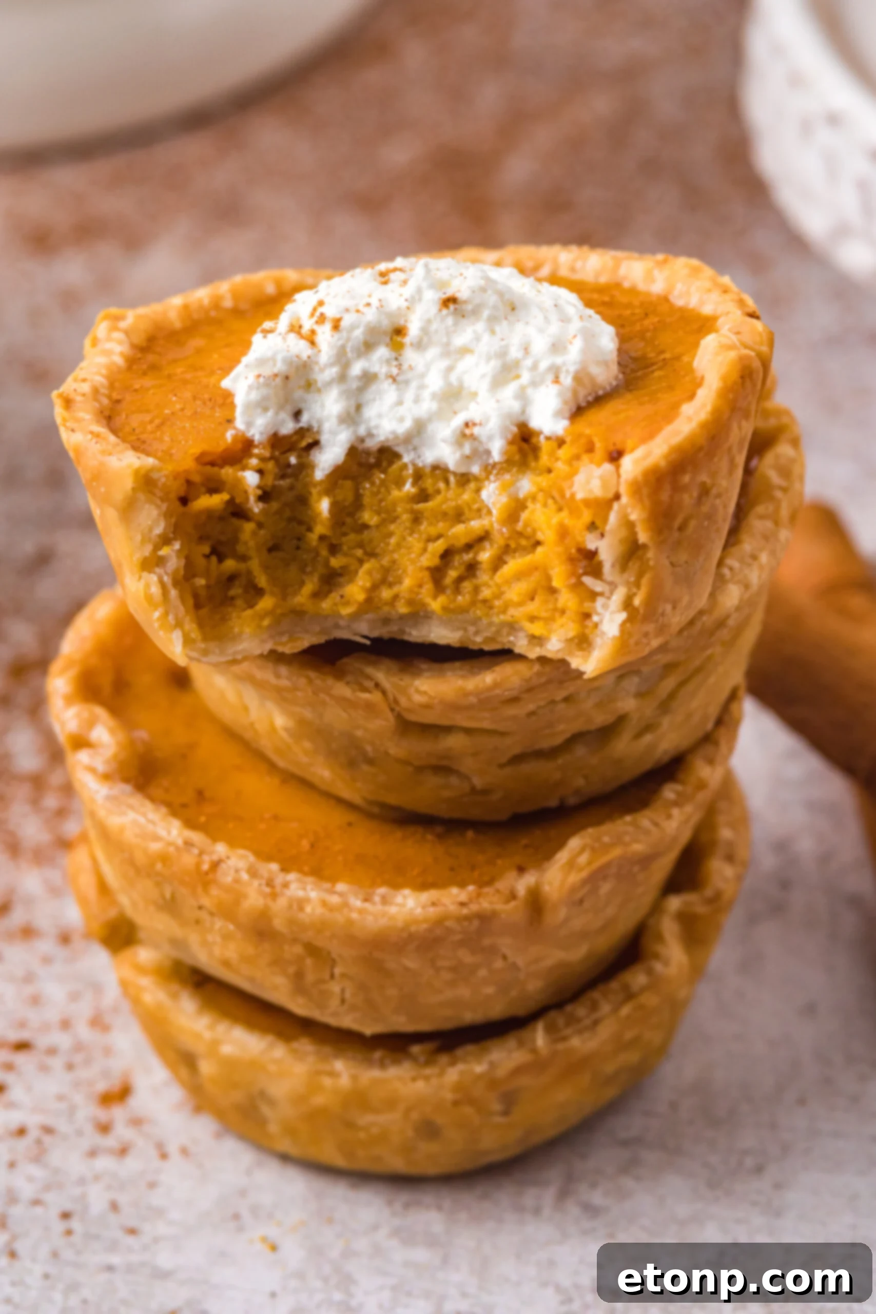 Stack of mini pumpkin pies with a bite missing