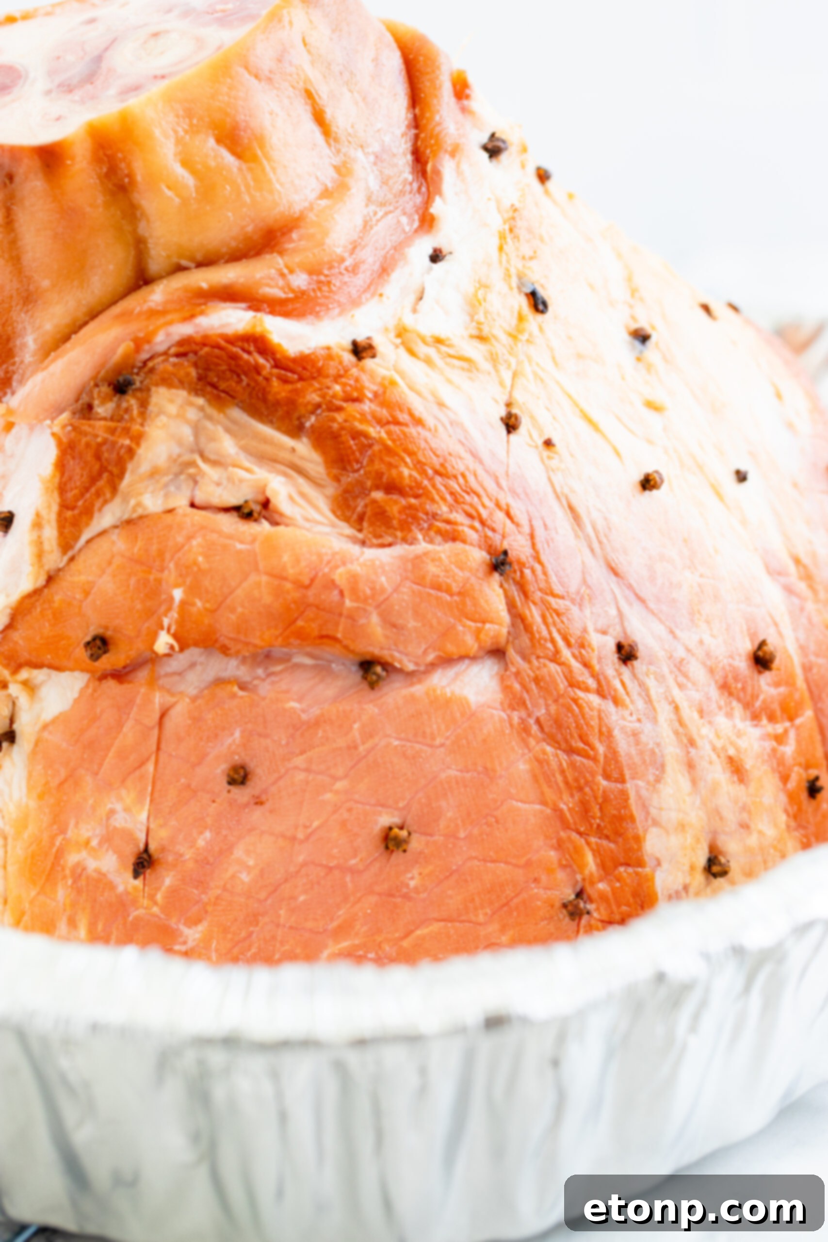 placing whole cloves into the side of the ham. 