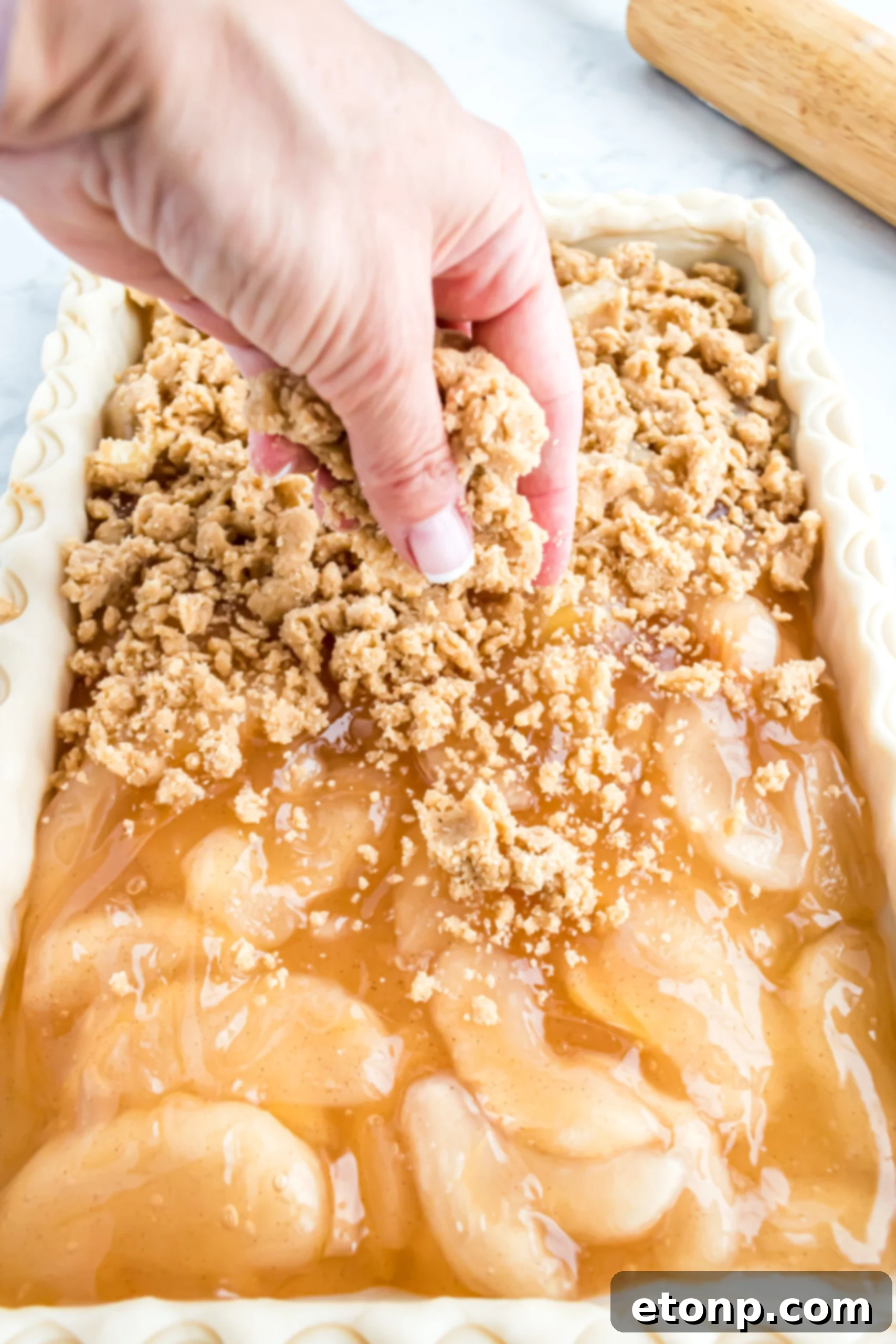 Adding the crumble on top of the apple filling. 