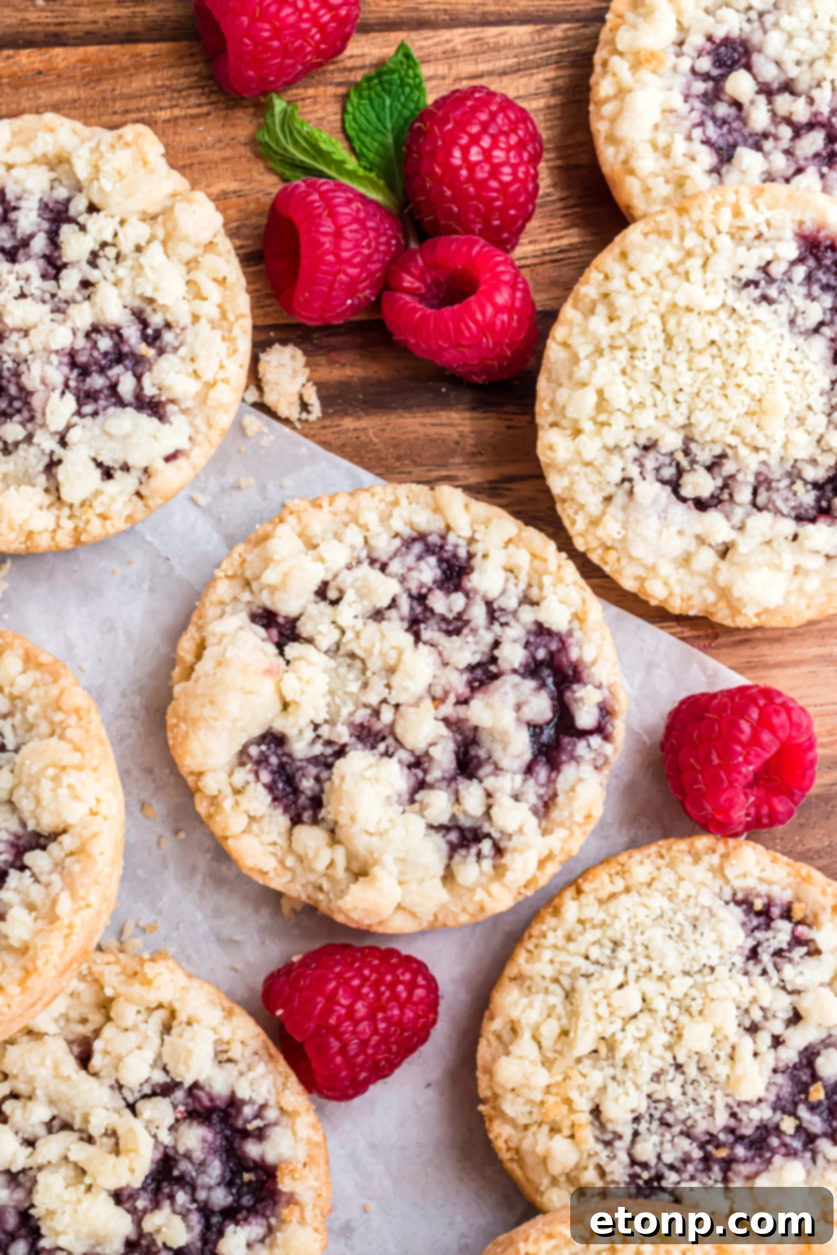 Overhead shot of the cookies arranged on wax paper with fresh raspberries.