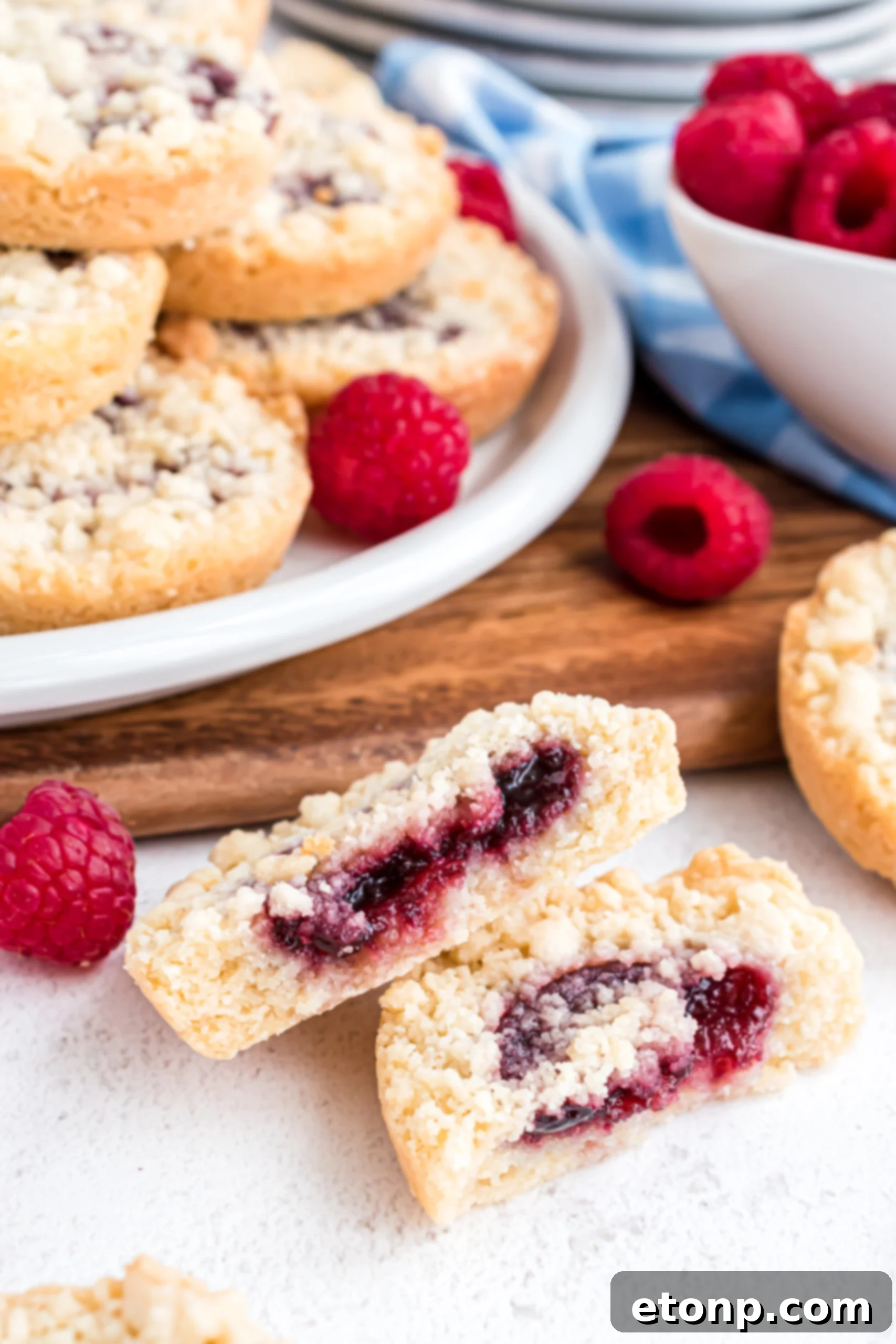 A raspberry cookie cut in half showing the raspberry filling center.