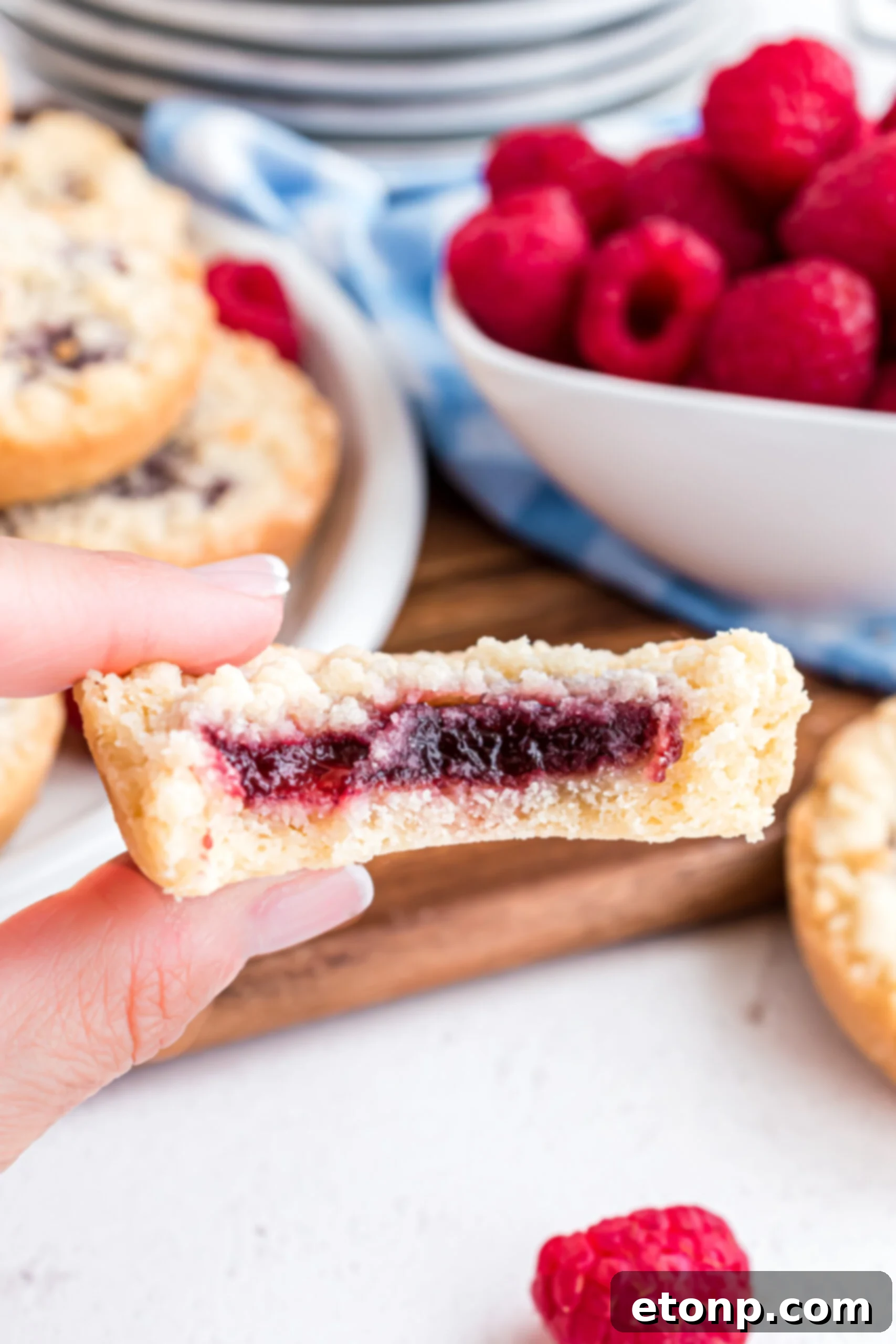 Close up shot of the inside of a raspberry cookie showing the jam filling.
