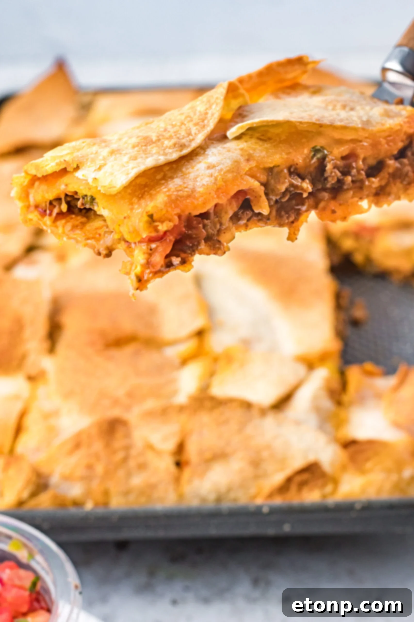 A piece of sheet pan tacos being removed from the baking sheet. 
