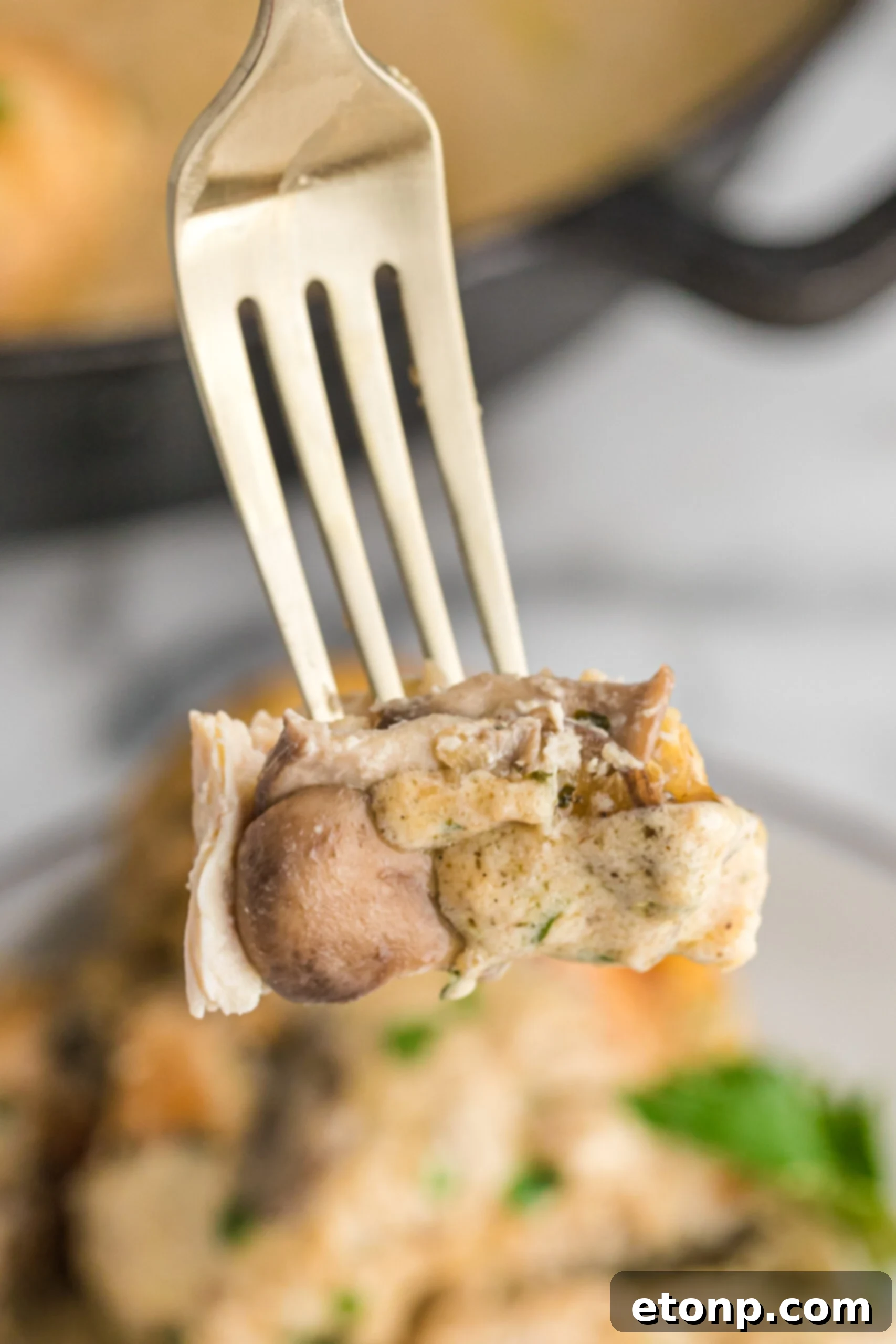 A close up shot of a piece of cheesy Garlic Butter Mushroom Stuffed Chicken 