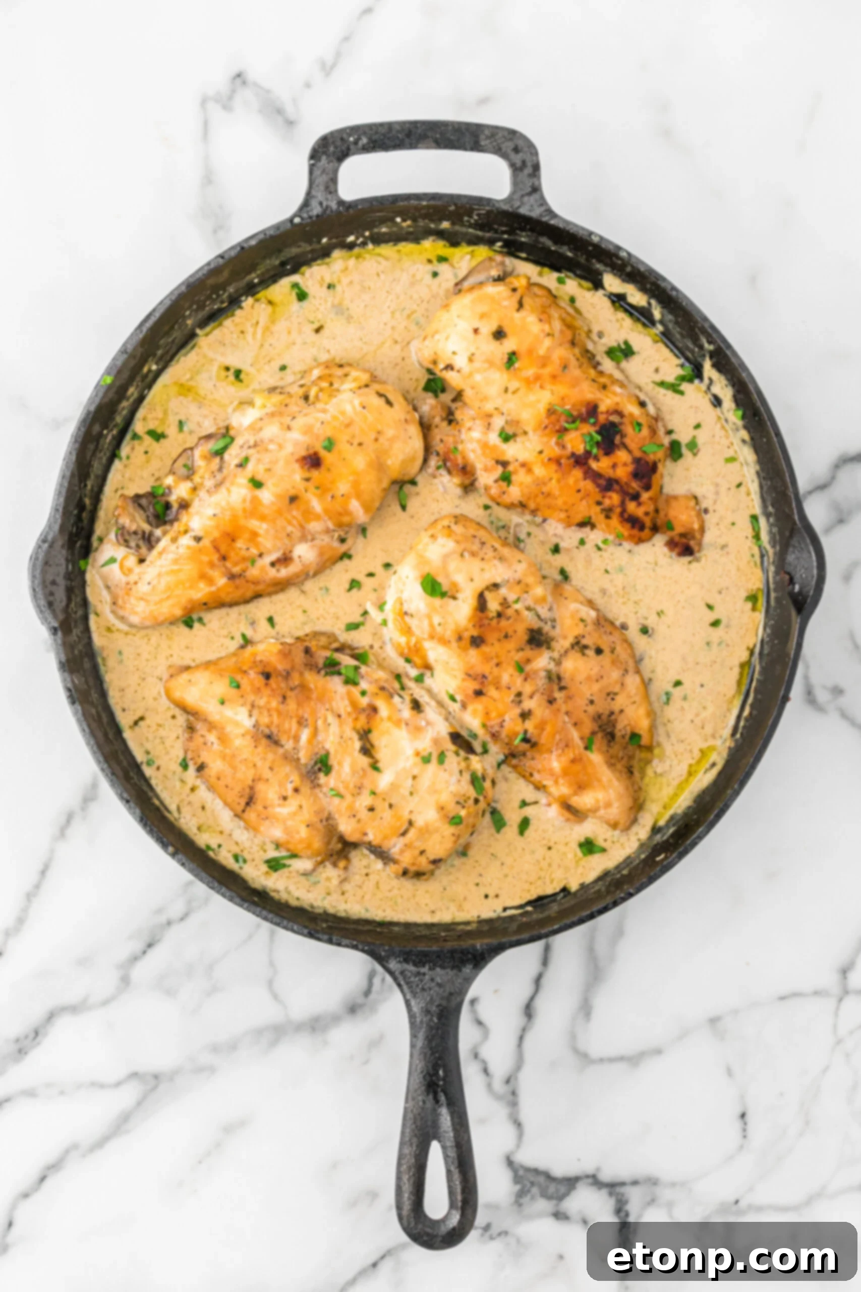 Overhead view of Cheesy Garlic Butter Mushroom Stuffed Chicken in a cast iron skillet. 
