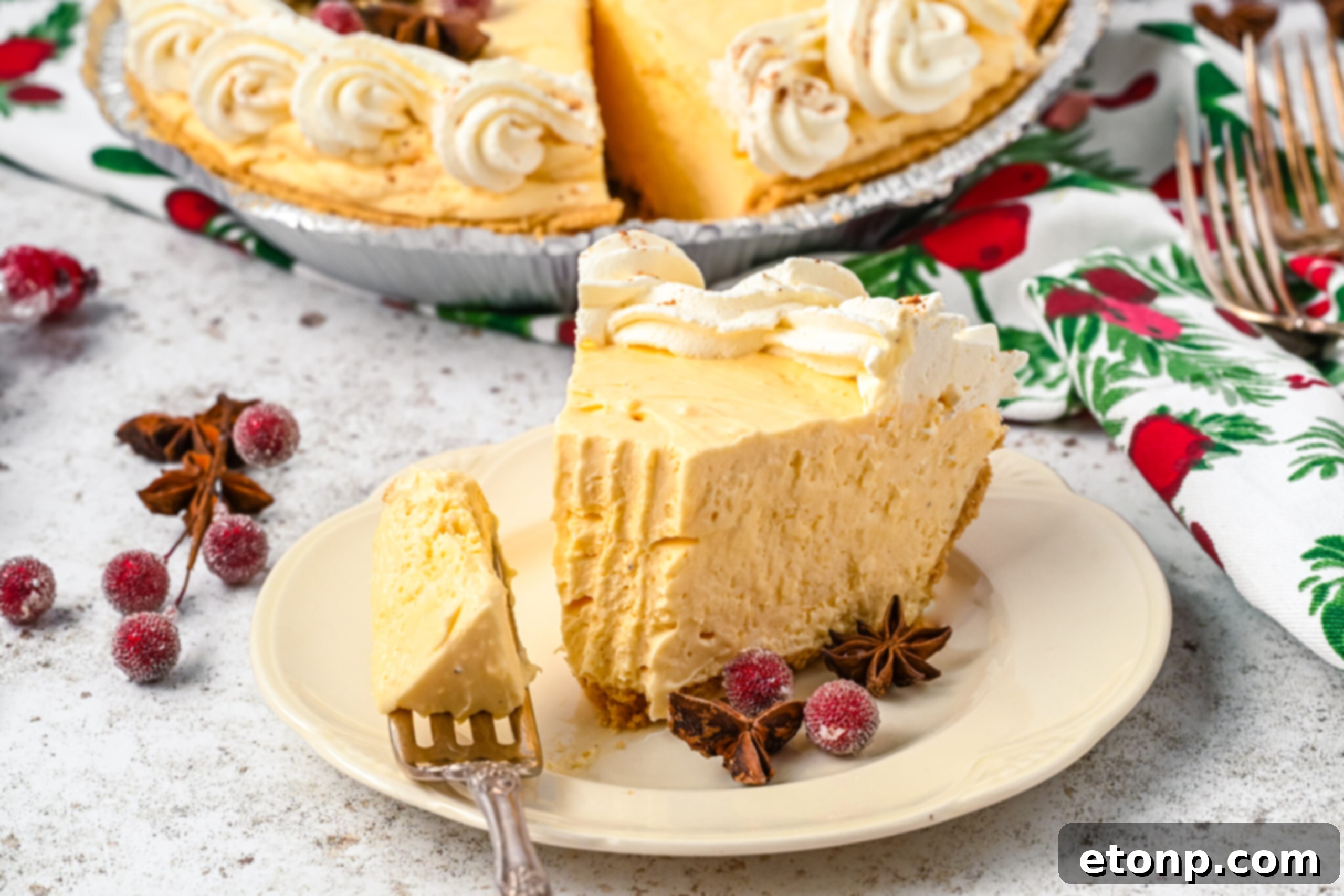 Velvety Eggnog Pie 13 A tempting piece of Eggnog Pie on a white dish, with a silver fork gracefully removing a portion, indicating its soft and inviting texture.