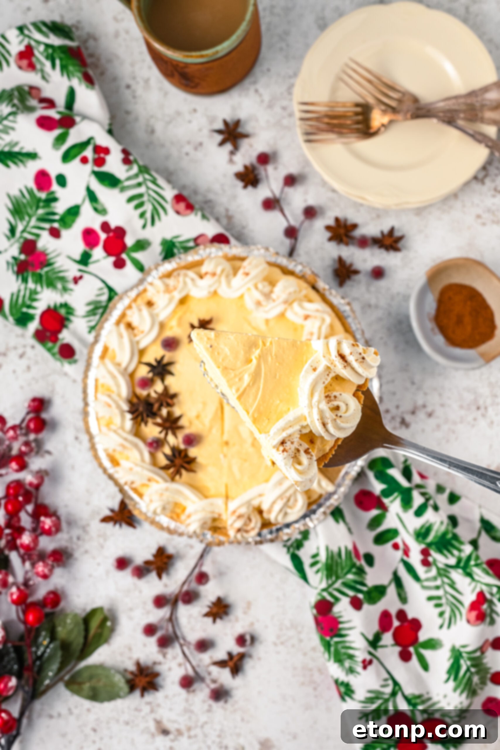 Velvety Eggnog Pie 4 Overhead view of a perfect piece of Eggnog Pie being gracefully removed from the baking dish with a shimmering silver spatula, showcasing its firm structure.