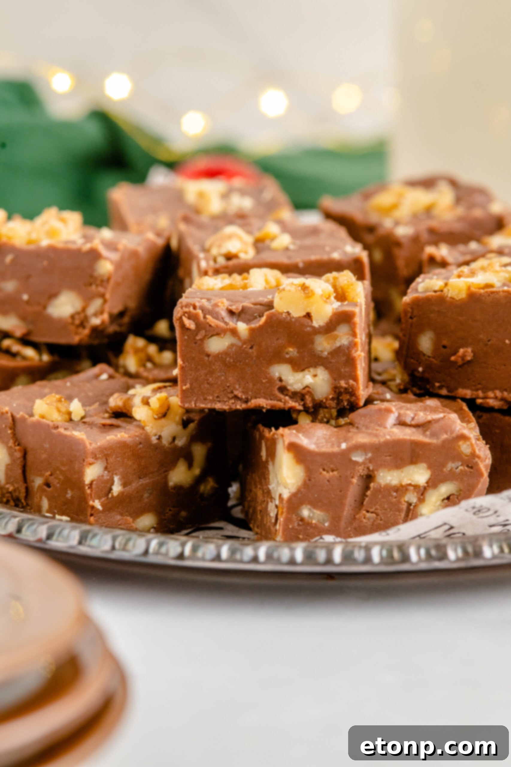 Fantasy Fudge stacked on a tin serving tray with twinkle lights in the background. 