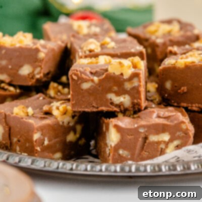A piece of fantasy fudge on a brown plate with a bite removed showing the inside. 