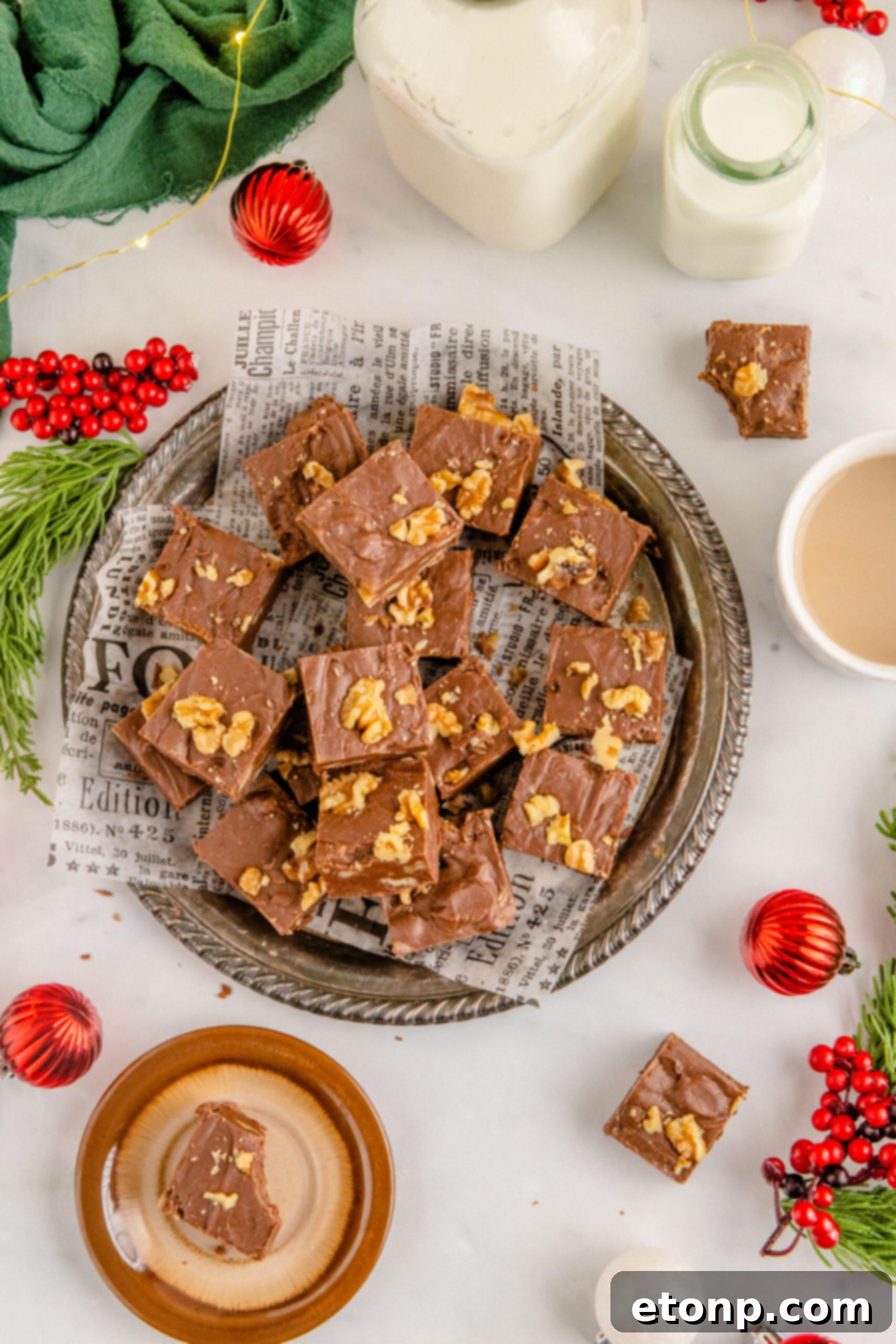 Overhead shot of the fudge stacked on a tin serving tray with holiday decorations in the background. 