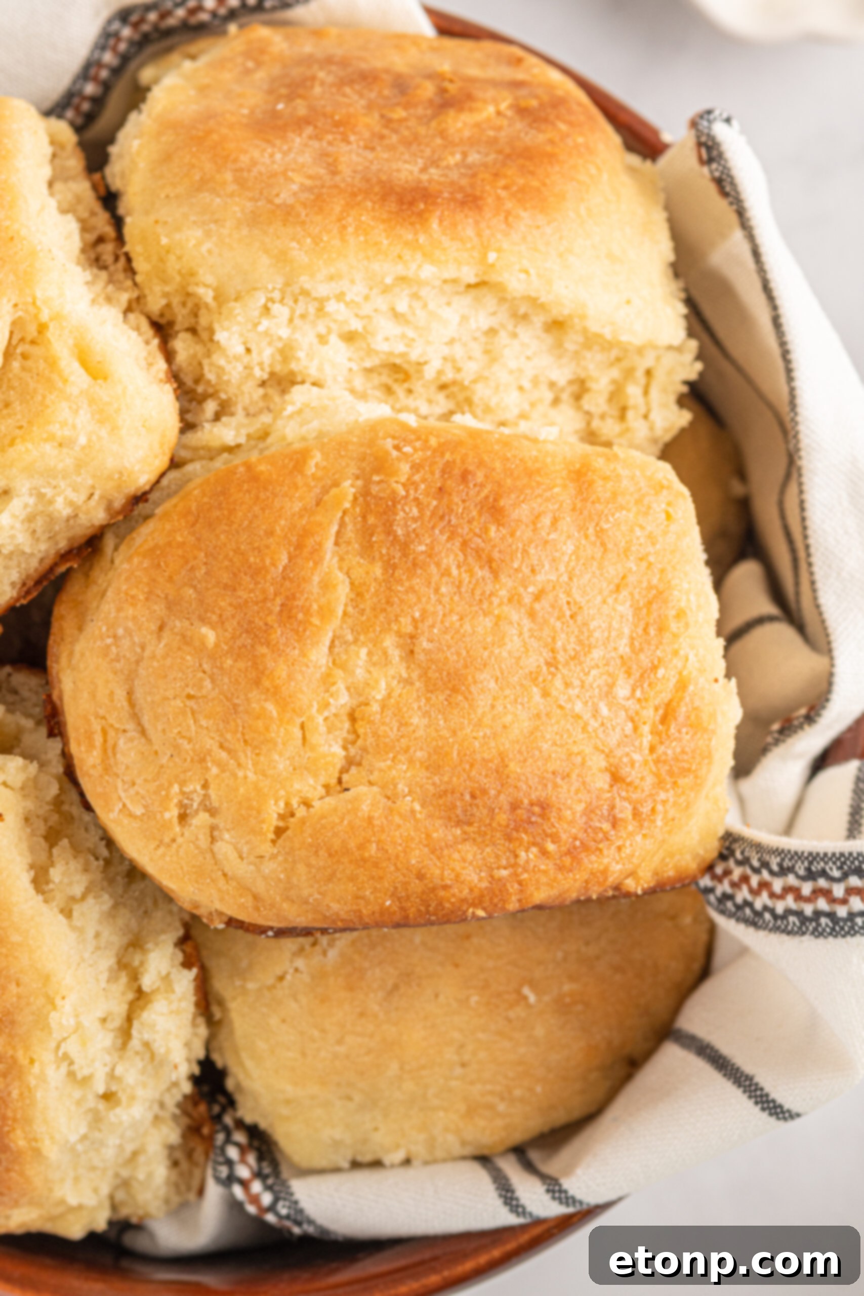 Close up of Angel Biscuits in a brown bowl with a white and black linen. 