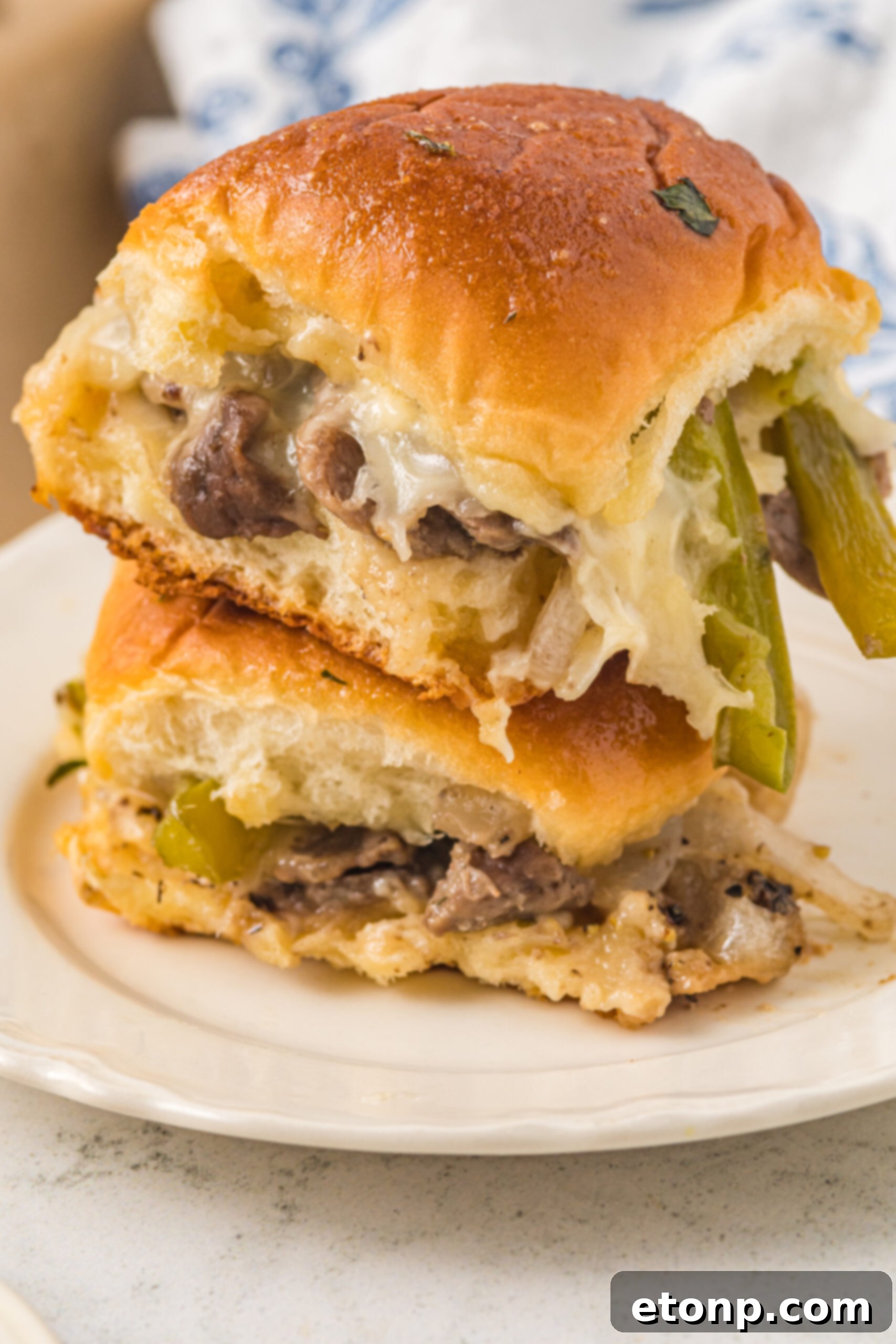 Two sliders stacked on a white plate. 