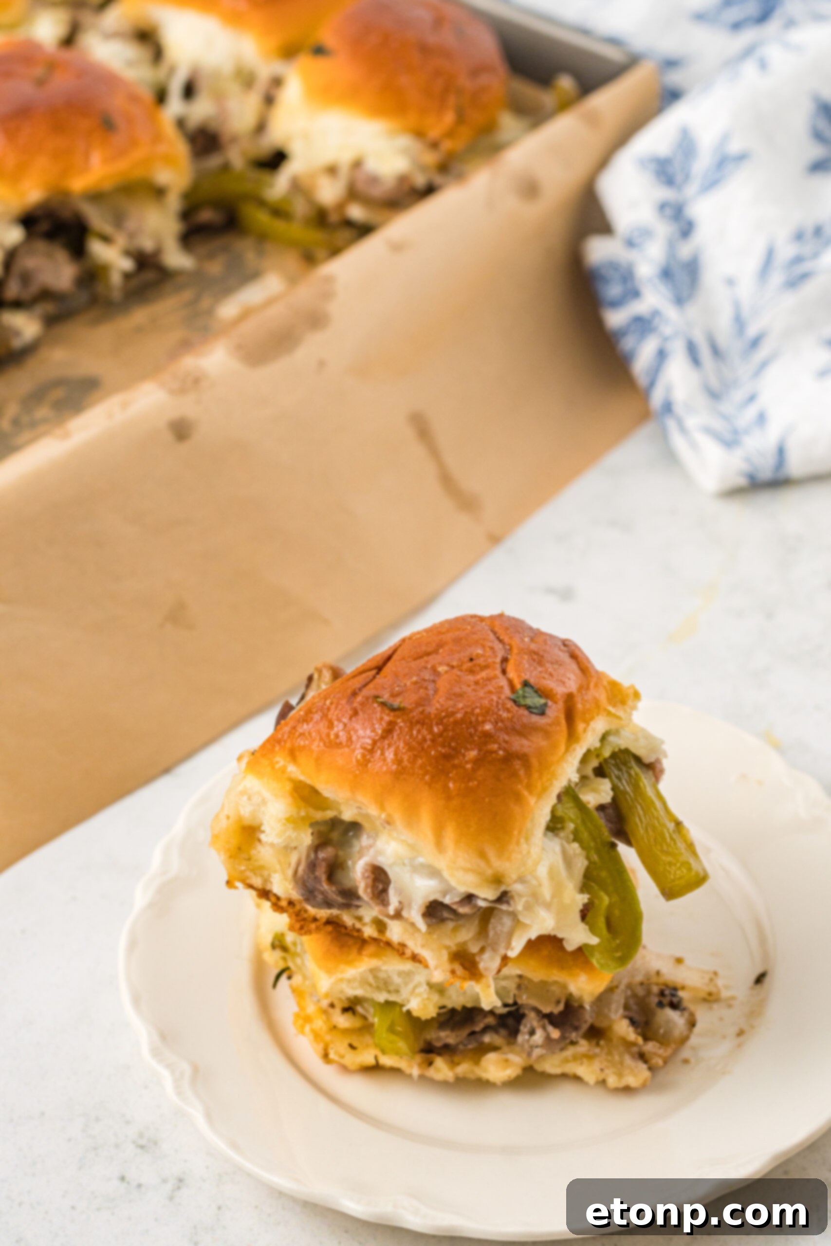 Two sliders stacked on a white plate. 
