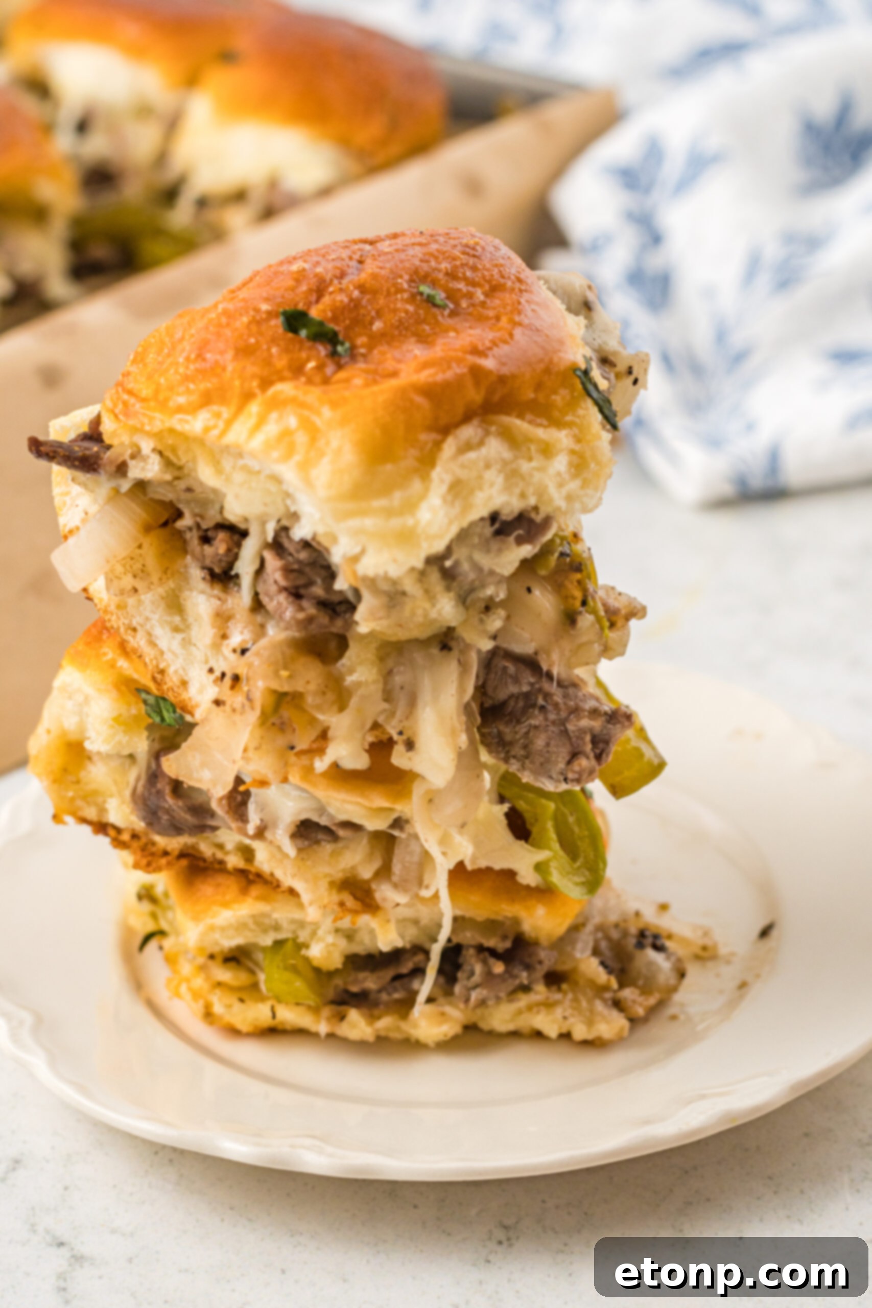Three sliders stacked on a white plate. 