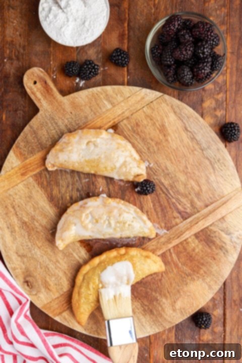 Rustic Blackberry Turnovers 12 Overhead shot of brushing the glaze on top of the blackberry hand pies.