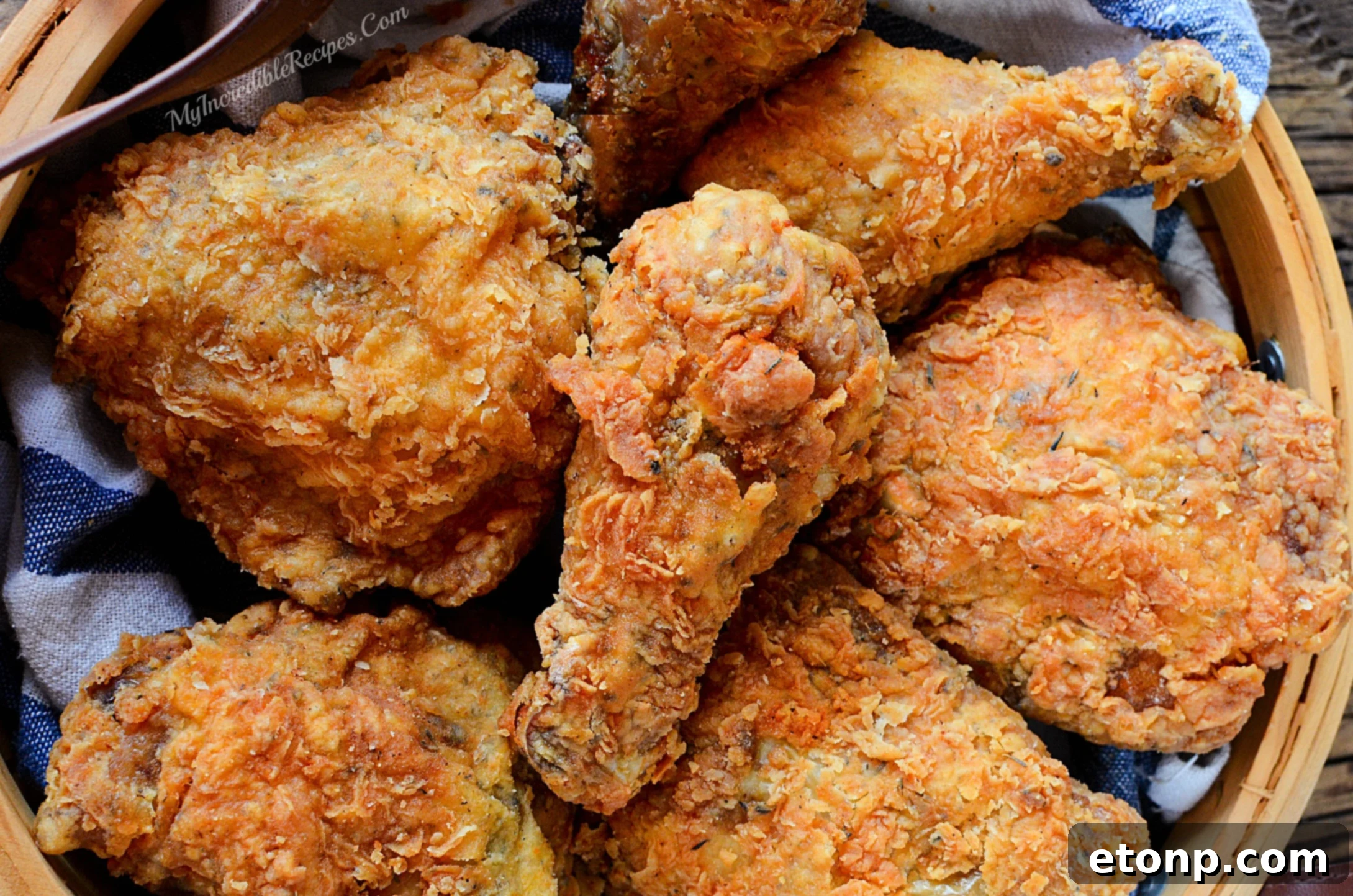 Crispy chicken being carefully placed into a hot oil skillet, ready for deep frying to golden perfection.