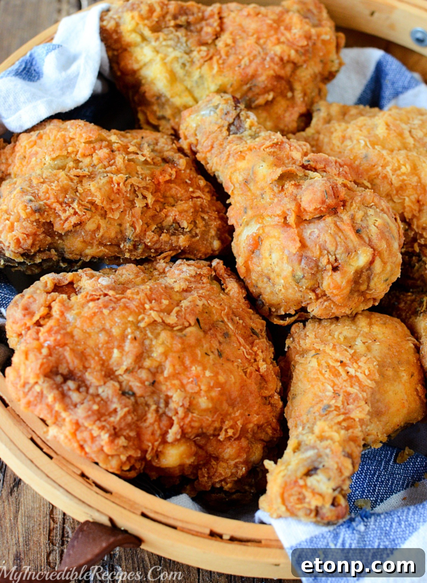 Close-up of a single piece of perfectly fried chicken, highlighting its crispy, seasoned skin and juicy interior.