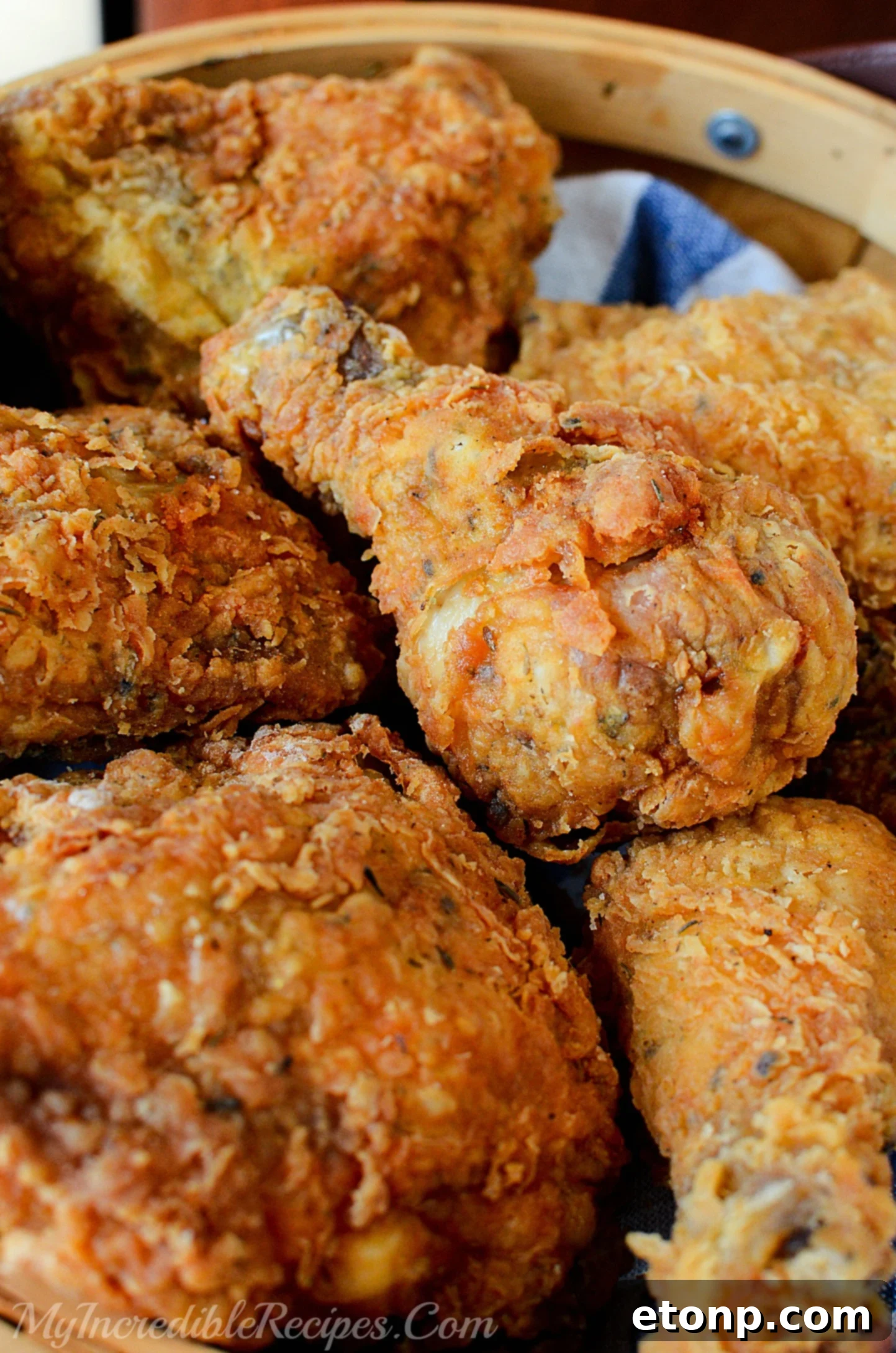 Freshly fried chicken pieces draining on a cooling rack, steam gently rising, emphasizing their tender, hot quality.