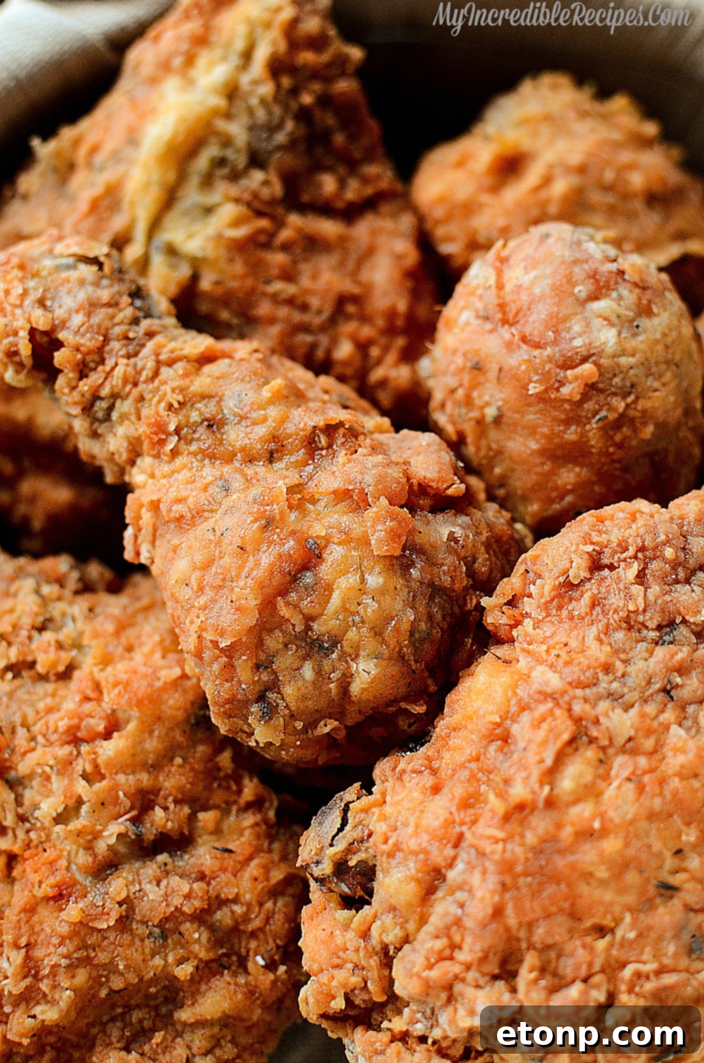 Close-up of a chicken thigh being dredged in a seasoned flour mixture, ensuring a thick, even coating.