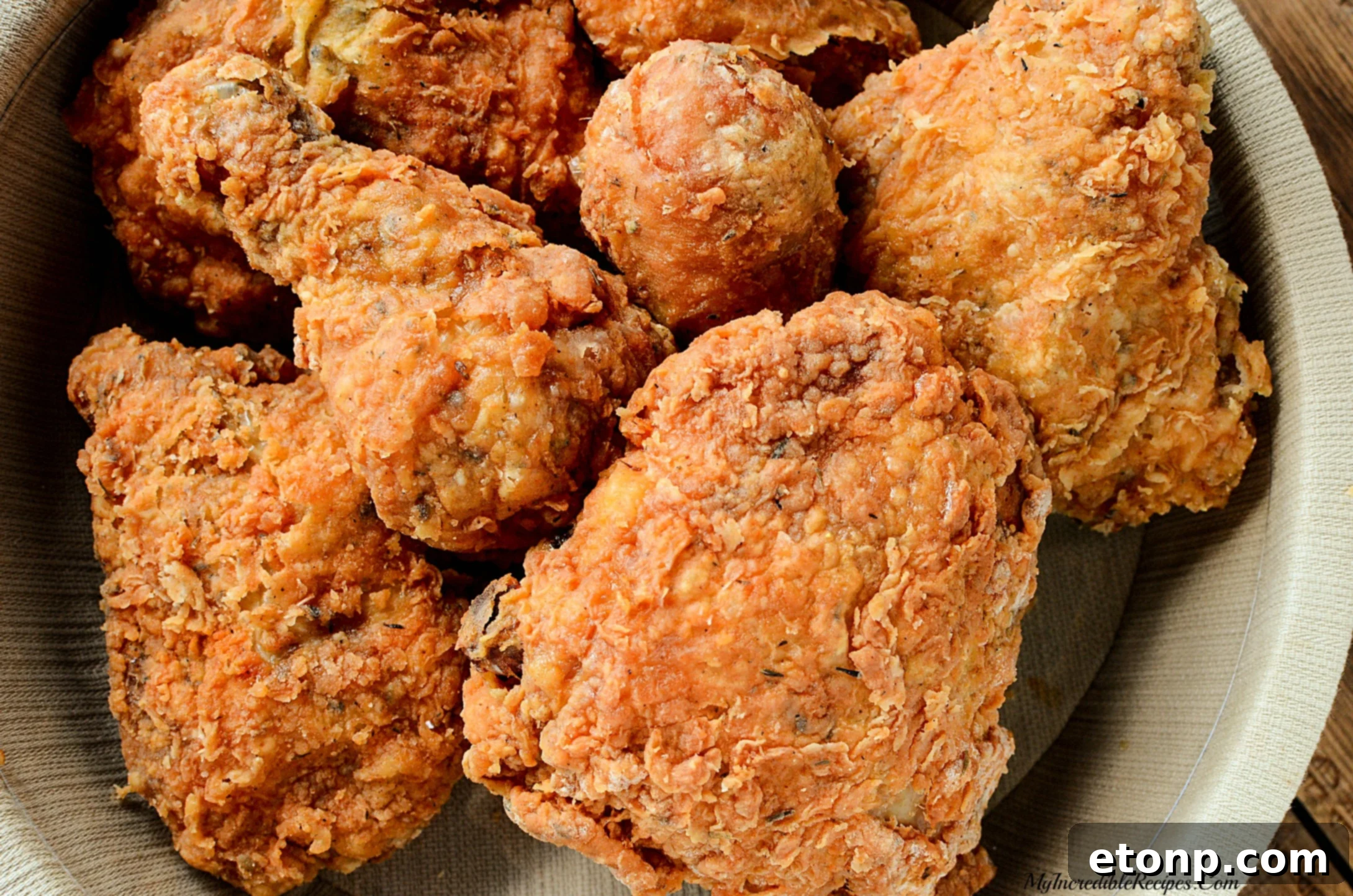Chicken pieces soaking in a bowl of buttermilk, essential for tenderizing and adding a tangy flavor to the meat.