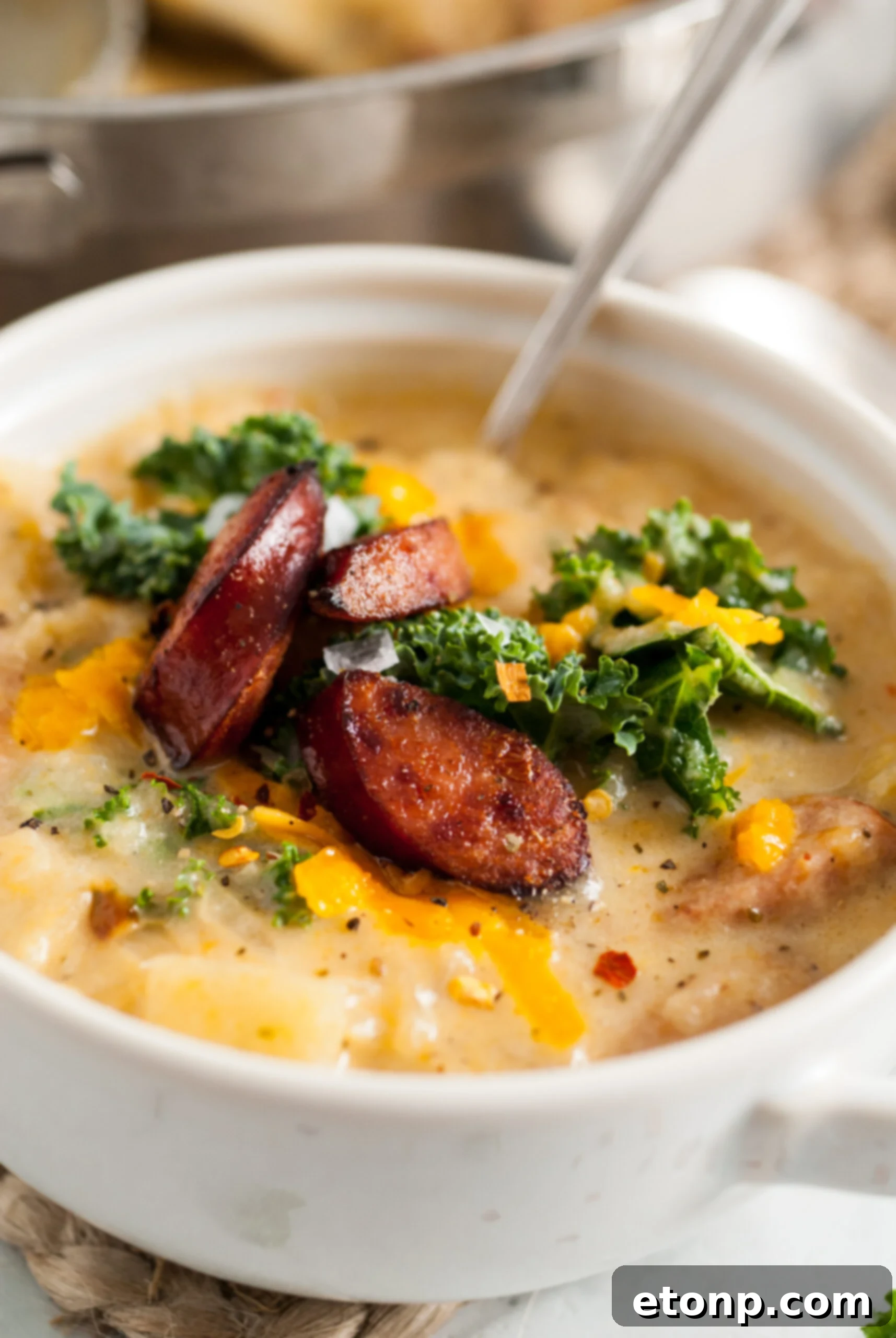 Close up shot of the soup topped with melted cheddar cheese and a sprinkle of herbs.